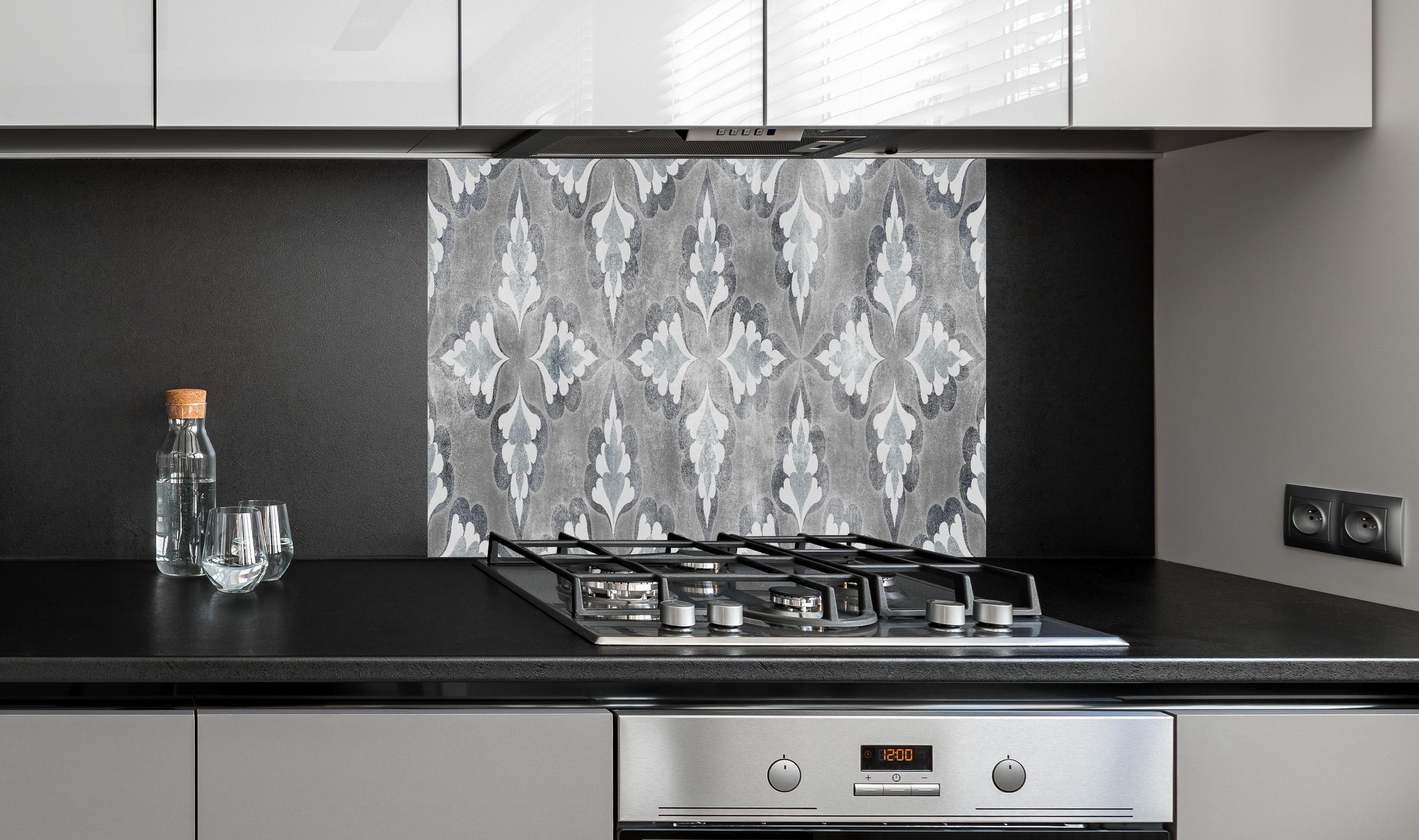 Spritzschutz - Elegante Grau-Weiß Zement Blattmuster Textur hinter einem Cerankochfeld zwischen Holz-Kochutensilien
