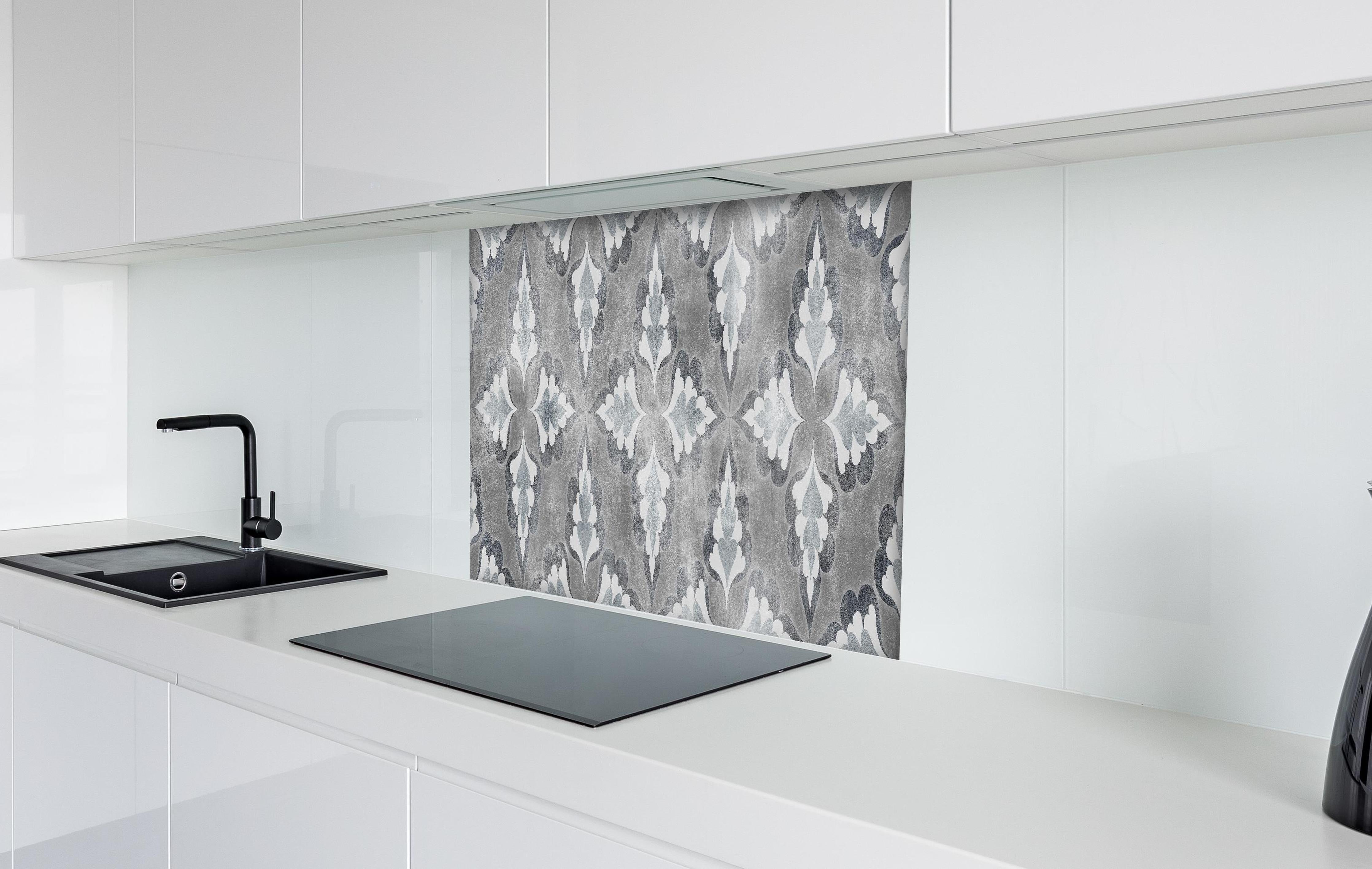 Spritzschutz - Elegante Grau-Weiß Zement Blattmuster Textur hinter einem Cerankochfeld zwischen Holz-Kochutensilien
