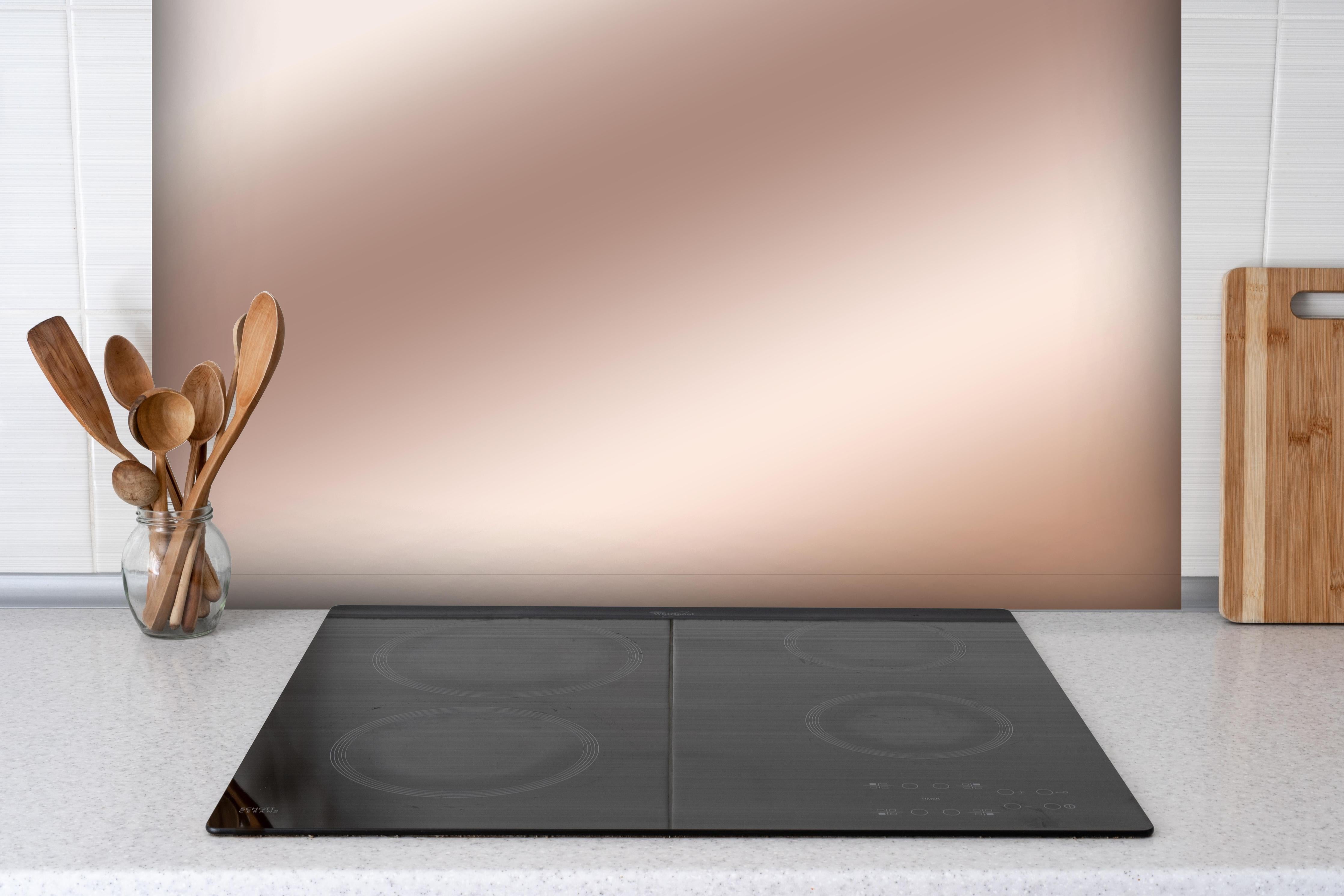 Spritzschutz - Elegante Metallic-Bronze Wand hinter einem Cerankochfeld zwischen Holz-Kochutensilien
