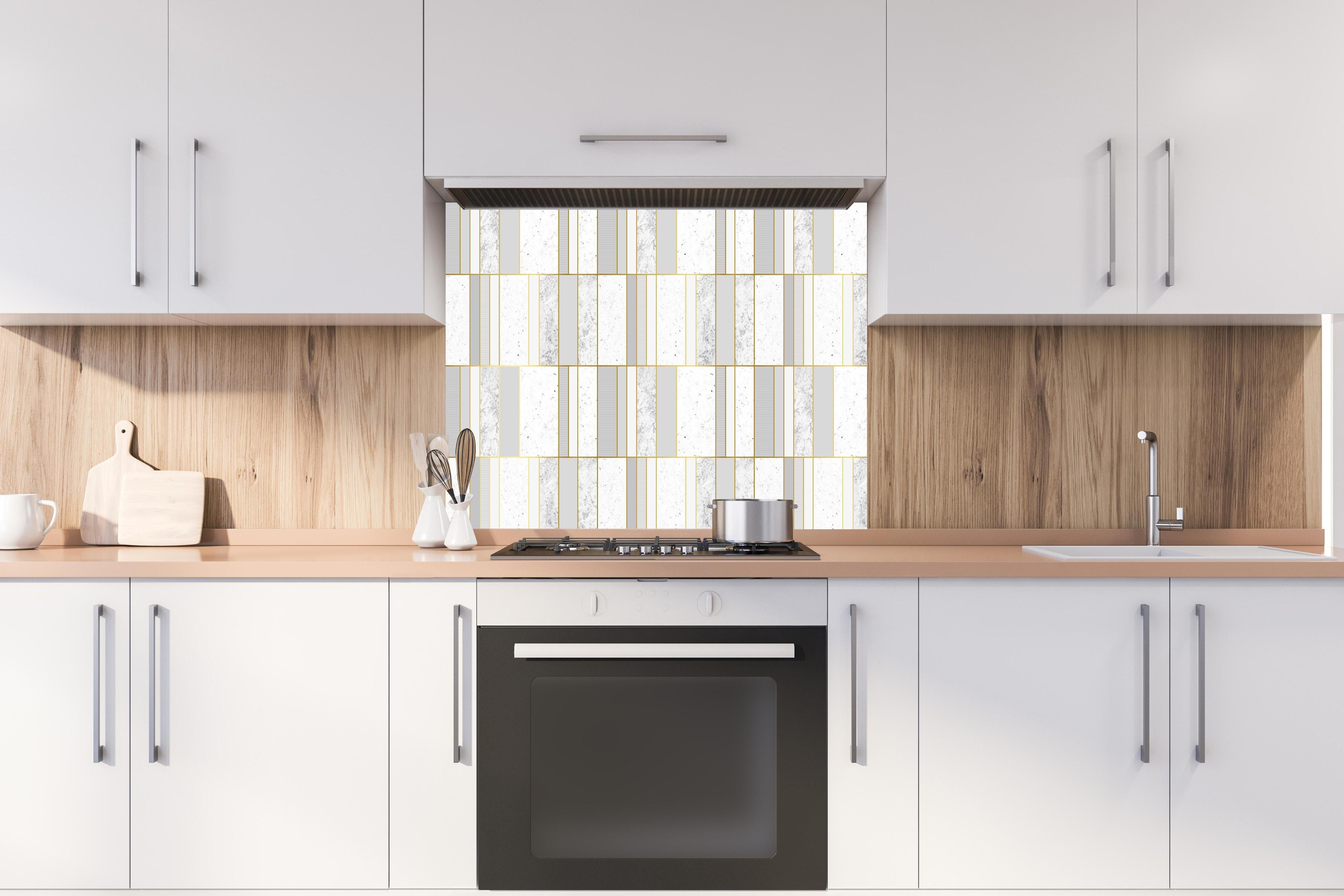 Spritzschutz - Elegante grauweiße Textur mit Goldlinien hinter einem Cerankochfeld zwischen Holz-Kochutensilien
