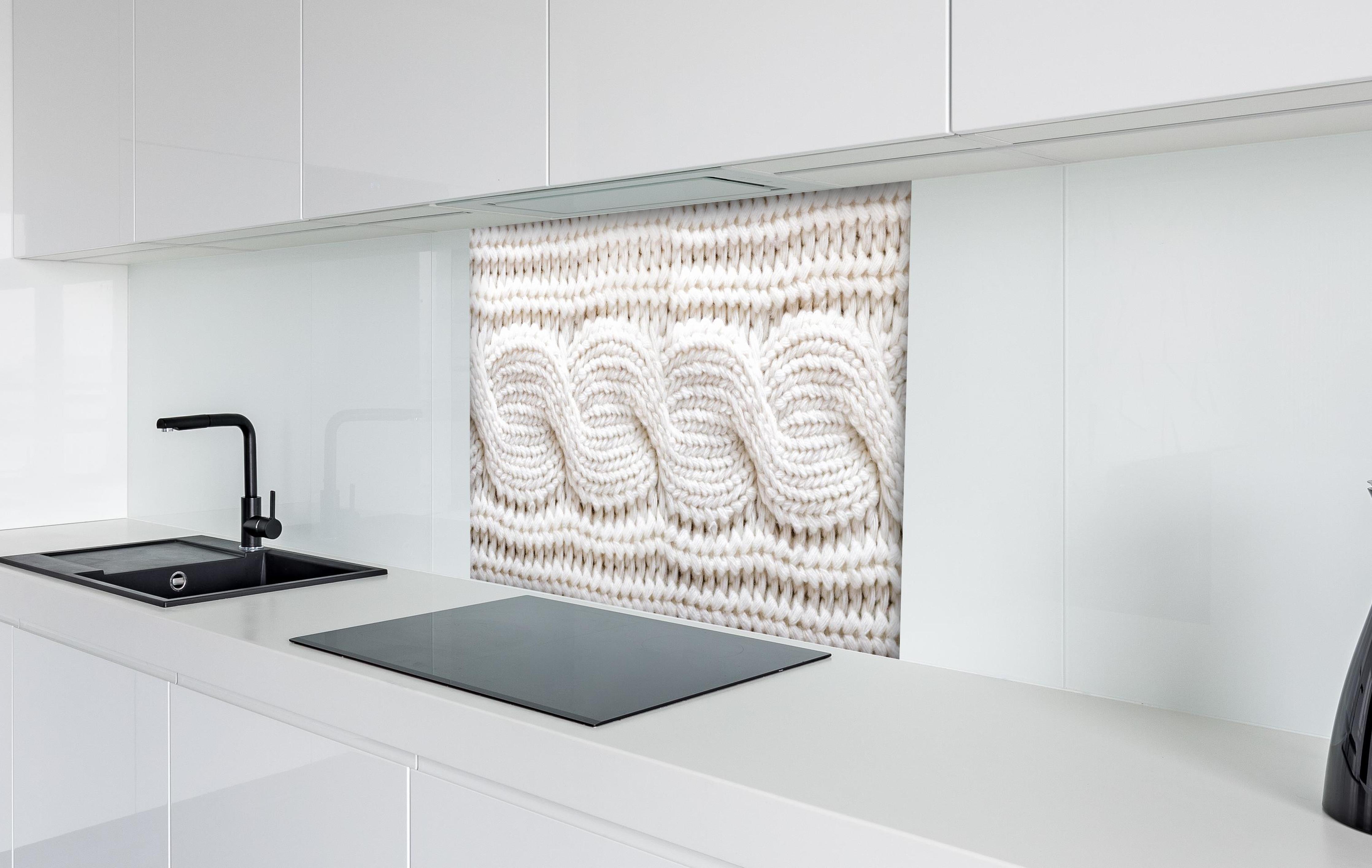 Spritzschutz - Elegante weiße Stricktextur aus Wolle hinter einem Cerankochfeld zwischen Holz-Kochutensilien
