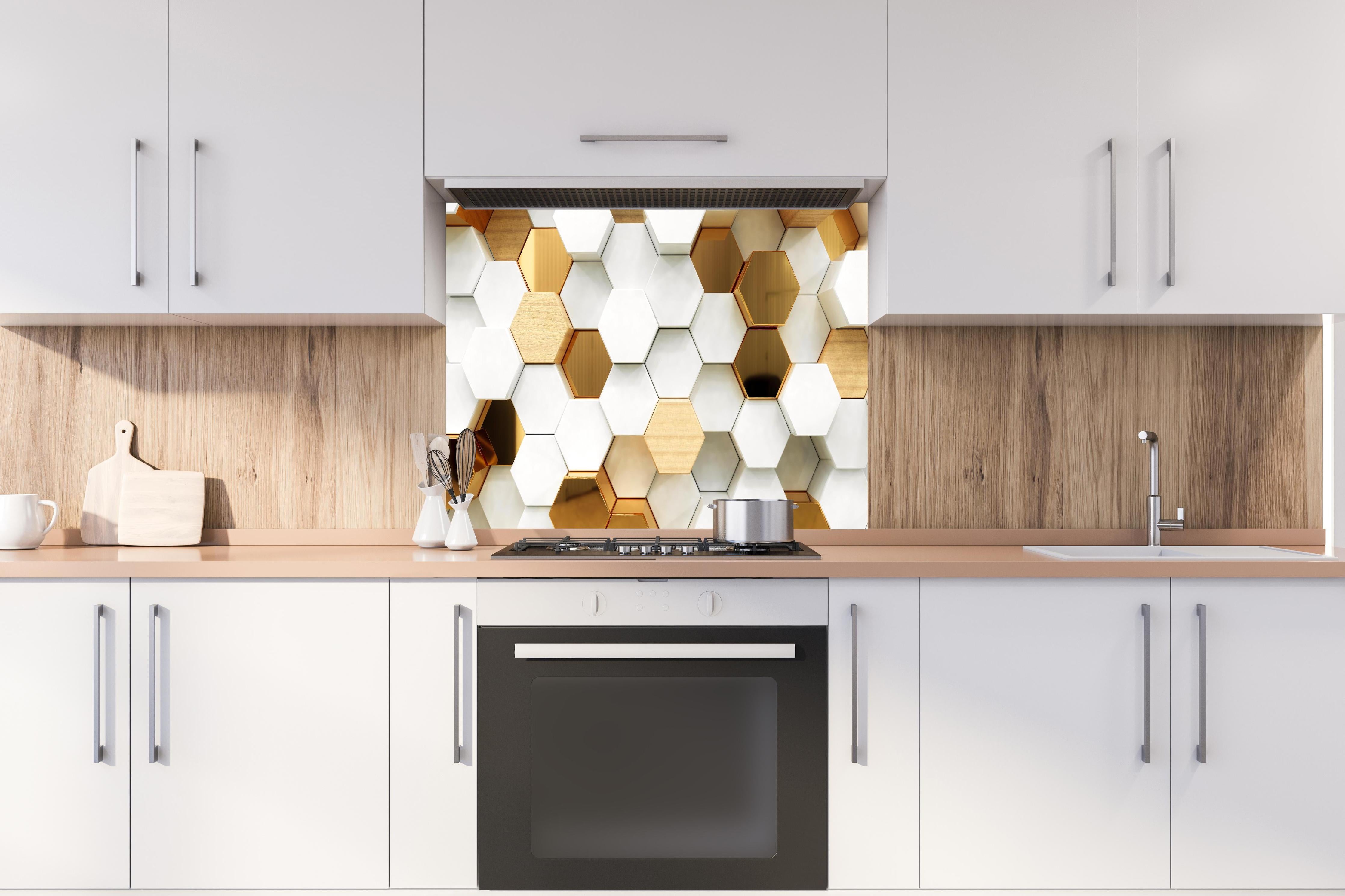 Spritzschutz - Eleganter weißer Hintergrund mit goldenen Hexagonen hinter einem Cerankochfeld zwischen Holz-Kochutensilien
