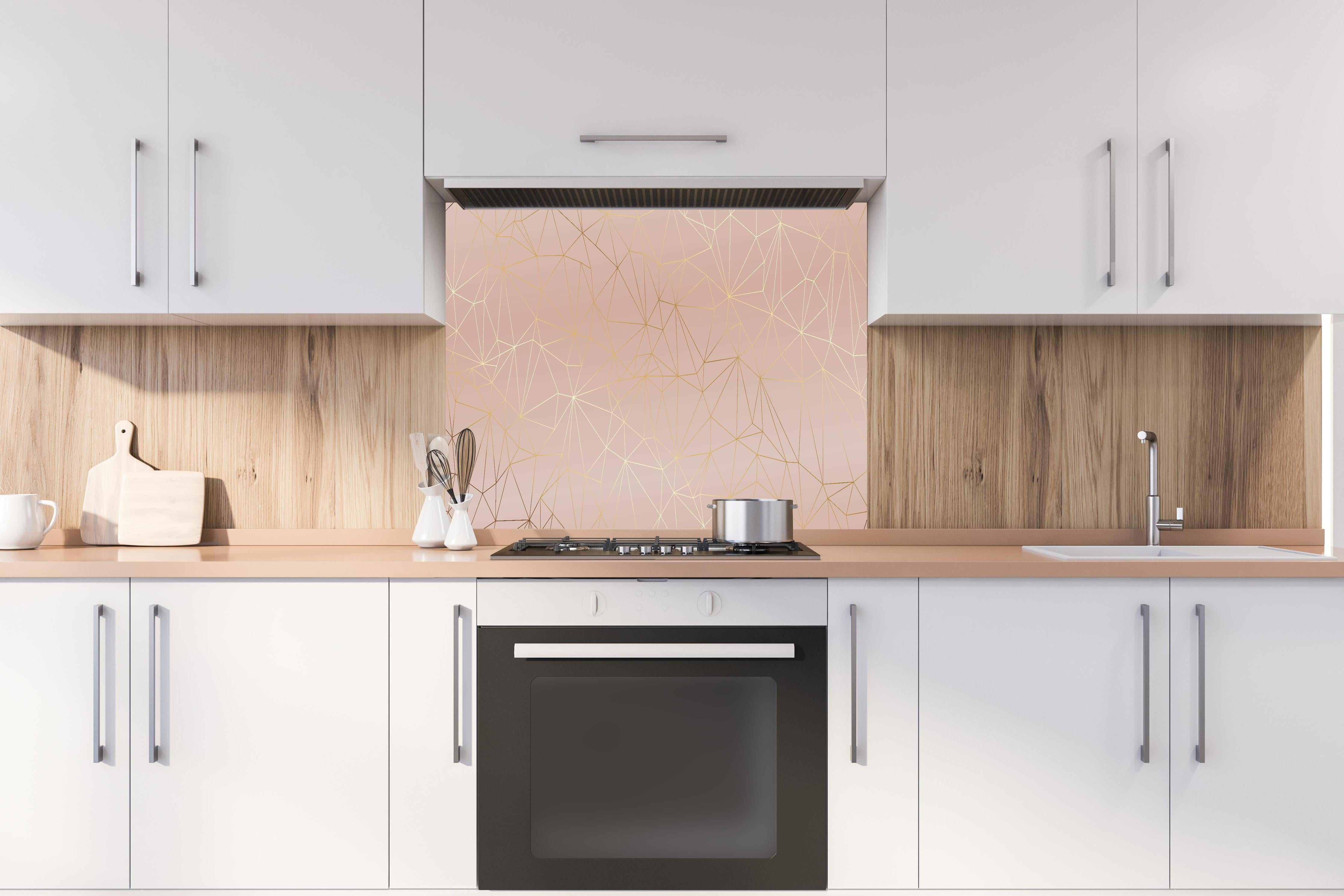 Spritzschutz - Elegantes Beige mit glänzenden goldenen Linien hinter einem Cerankochfeld zwischen Holz-Kochutensilien
