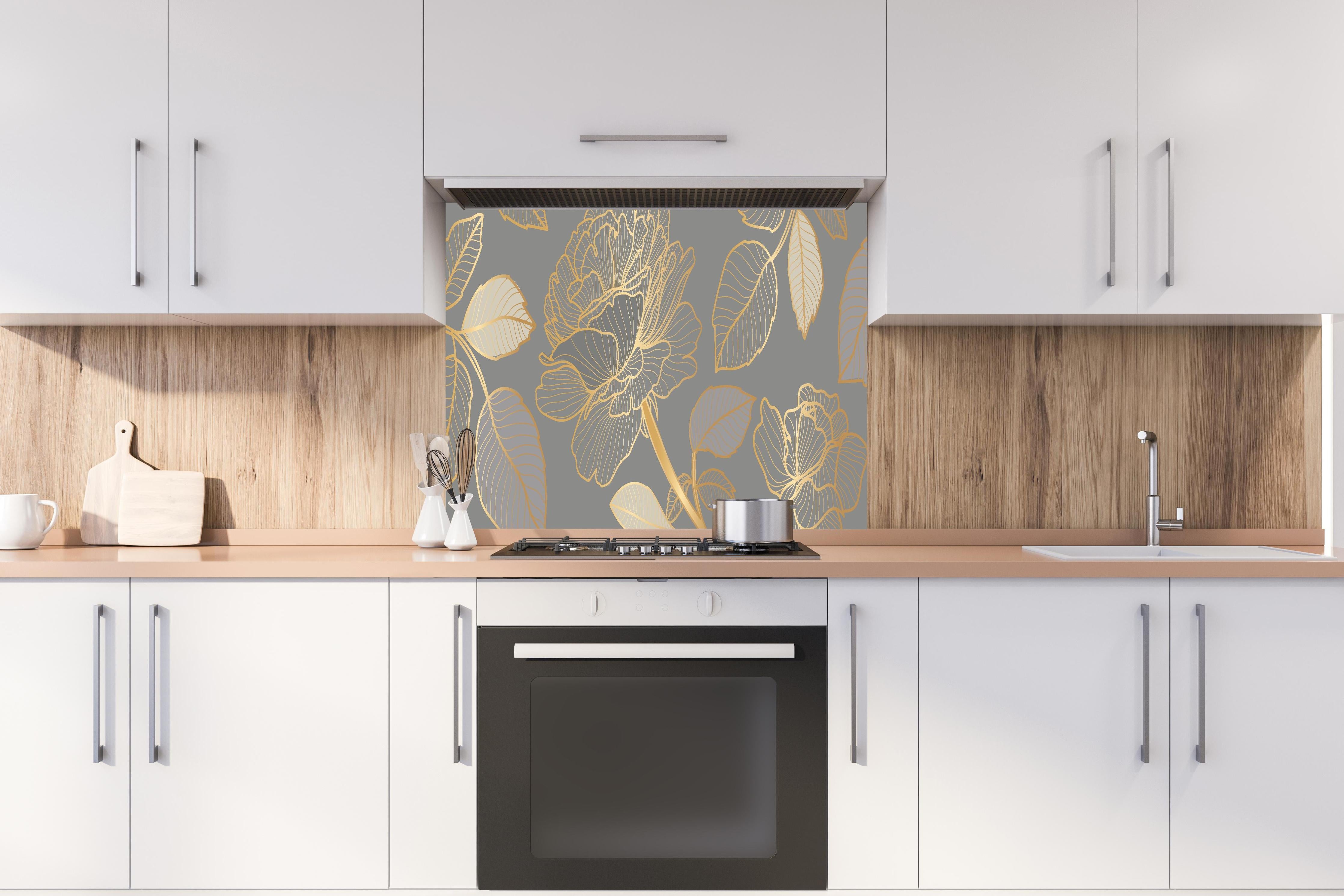 Spritzschutz - Elegantes Blumenmuster in Gold auf Grau hinter einem Cerankochfeld zwischen Holz-Kochutensilien
