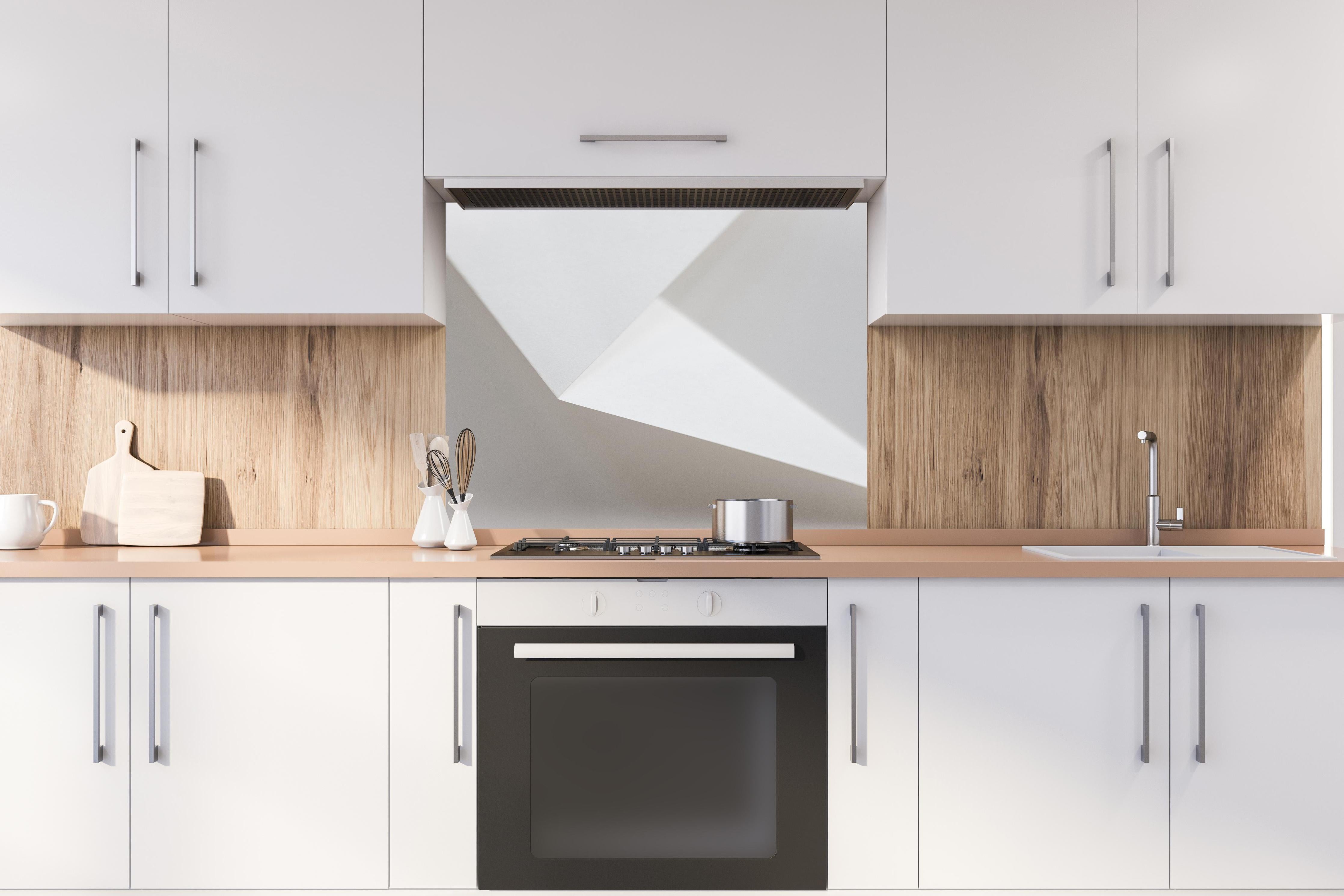 Spritzschutz - Elegantes Design Weiß und Schatten-Textur hinter einem Cerankochfeld zwischen Holz-Kochutensilien
