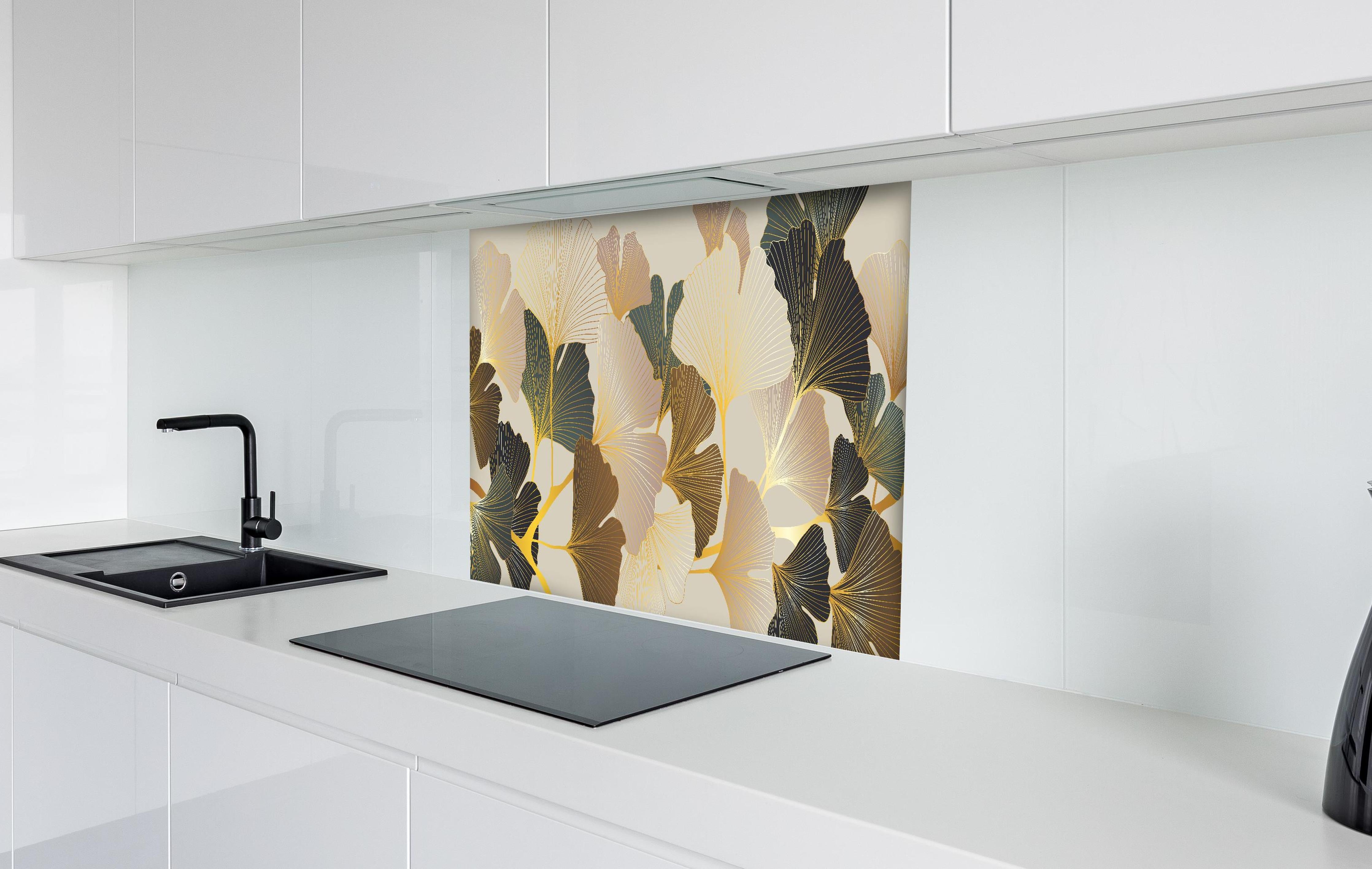 Spritzschutz - Elegantes Ginkgo-Blattmotiv mit goldfarbenen Akzenten hinter einem Cerankochfeld zwischen Holz-Kochutensilien

