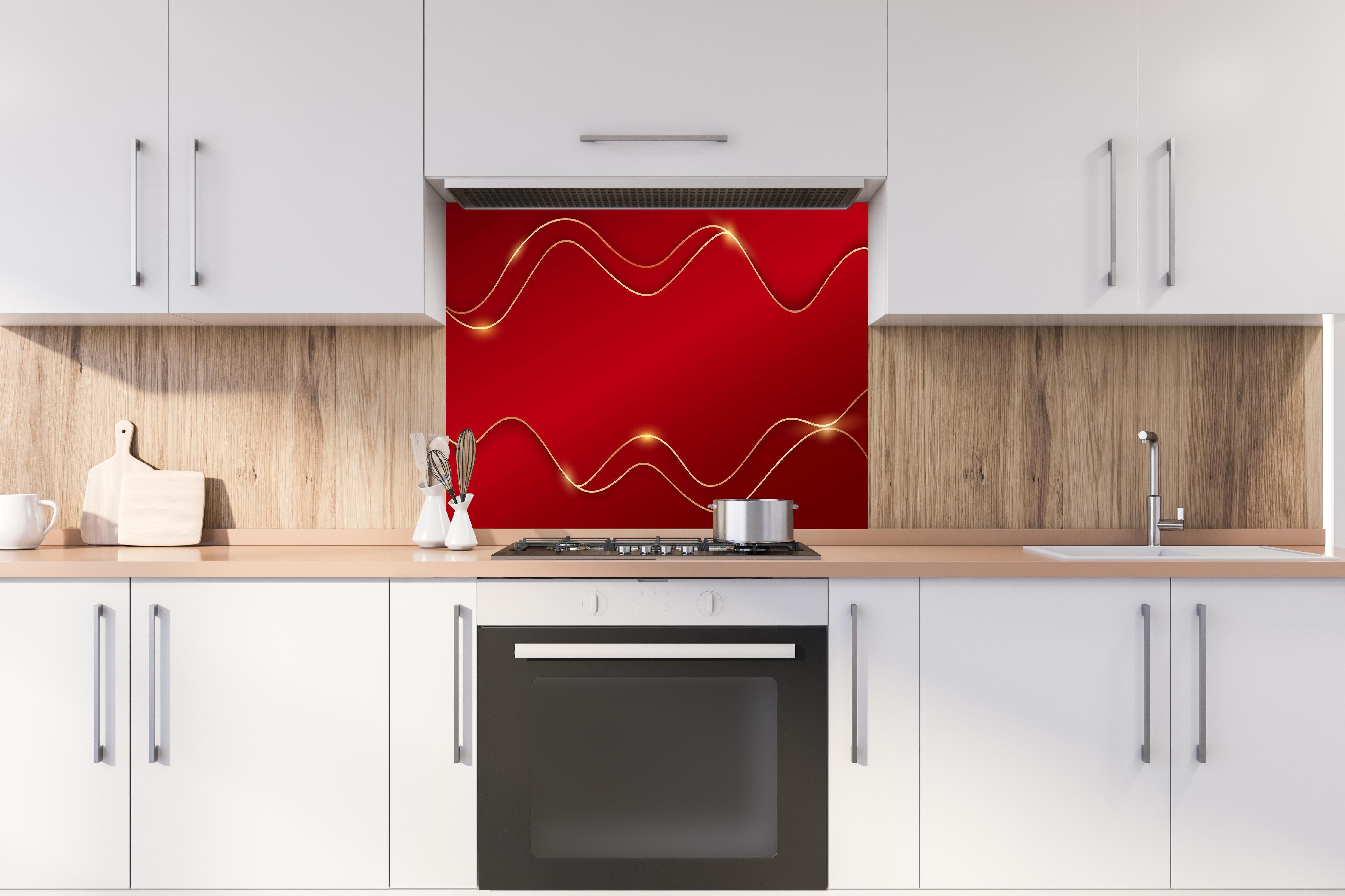 Spritzschutz - Elegantes Rot mit luxuriösen Goldlinien hinter einem Cerankochfeld zwischen Holz-Kochutensilien

