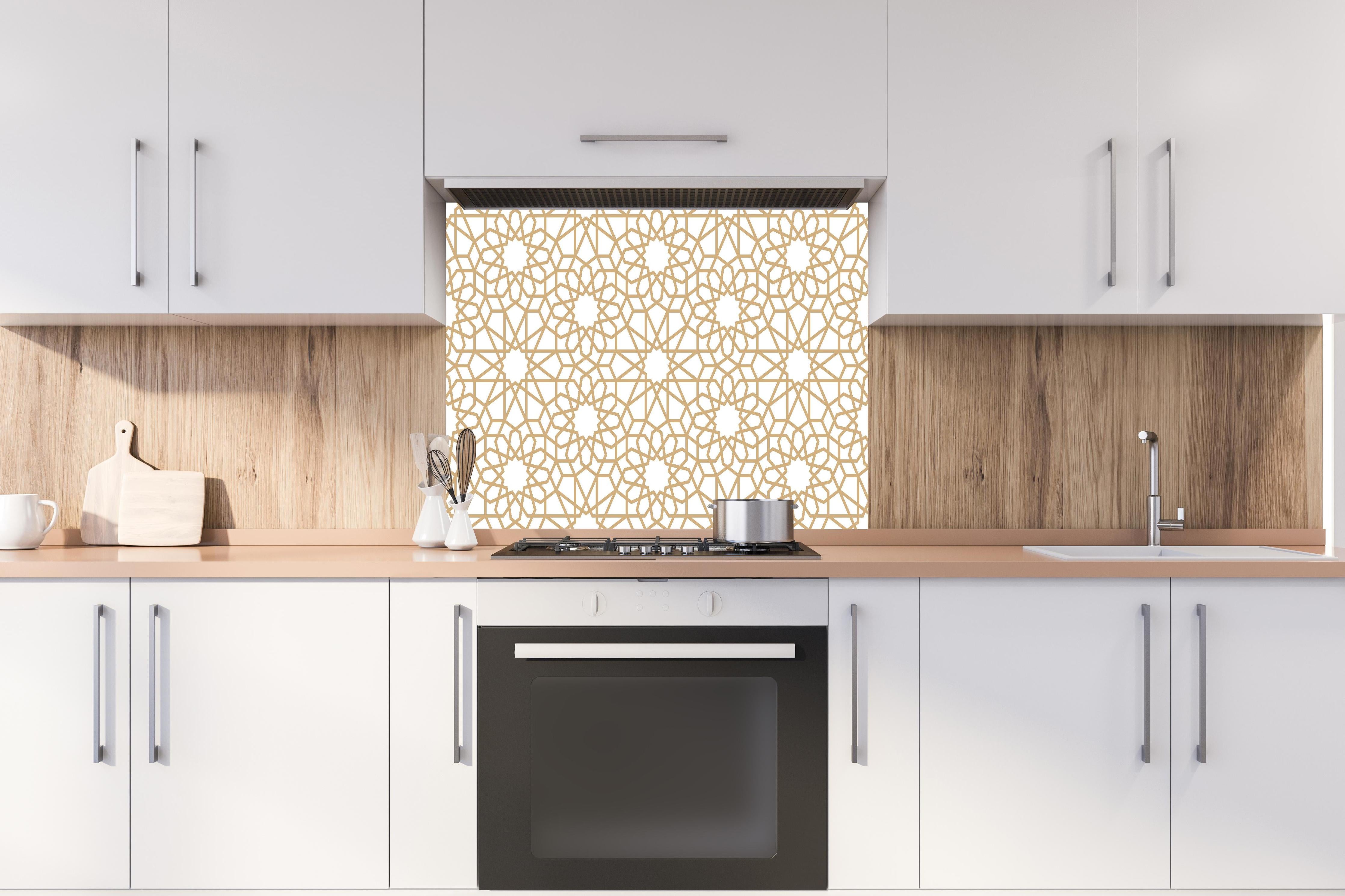 Spritzschutz - Elegantes goldenes Muster auf Weiß hinter einem Cerankochfeld zwischen Holz-Kochutensilien
