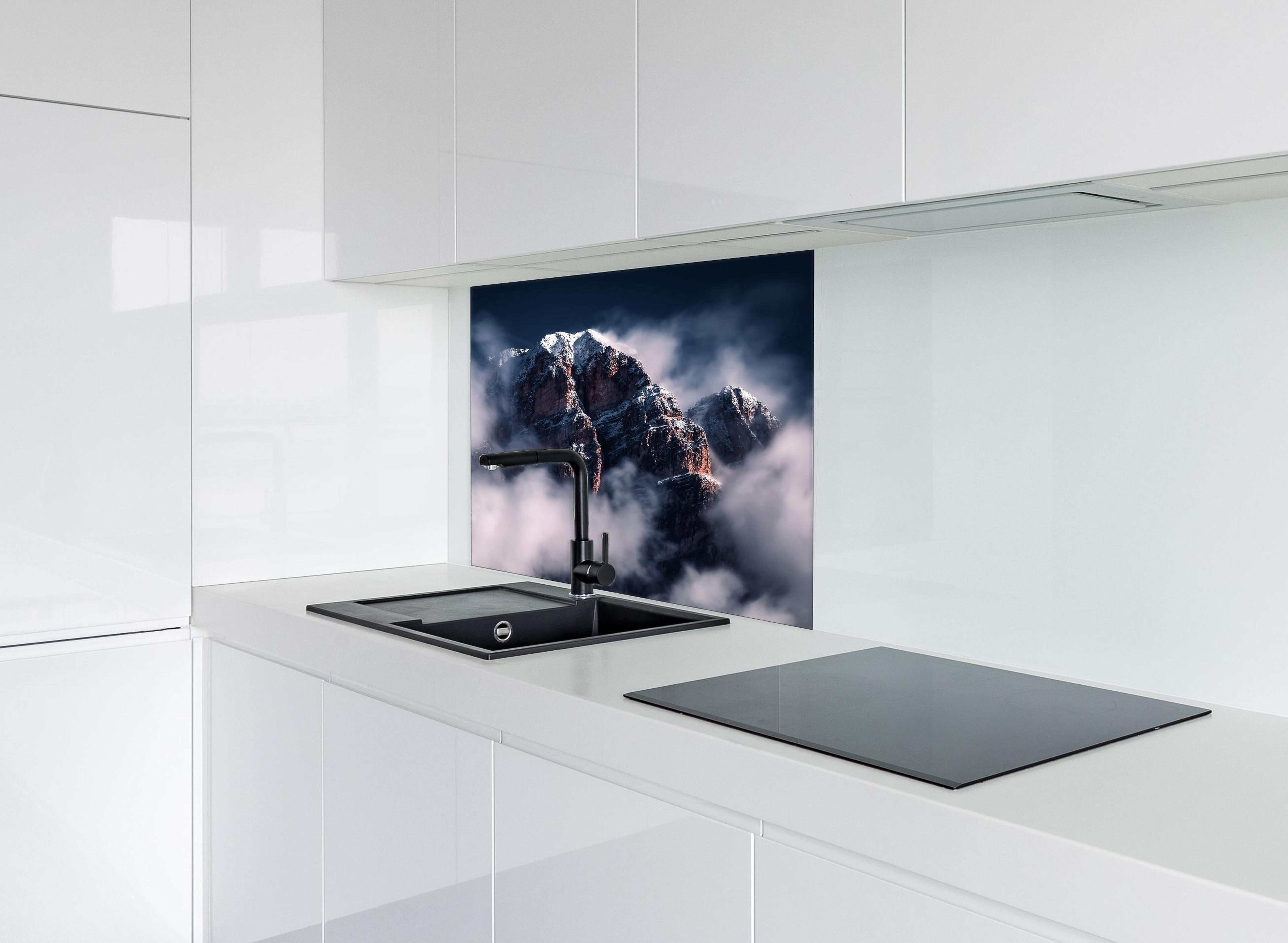 Spritzschutz - Erhabene Winterberge in Nebel und Schnee hinter einem Cerankochfeld zwischen Holz-Kochutensilien
