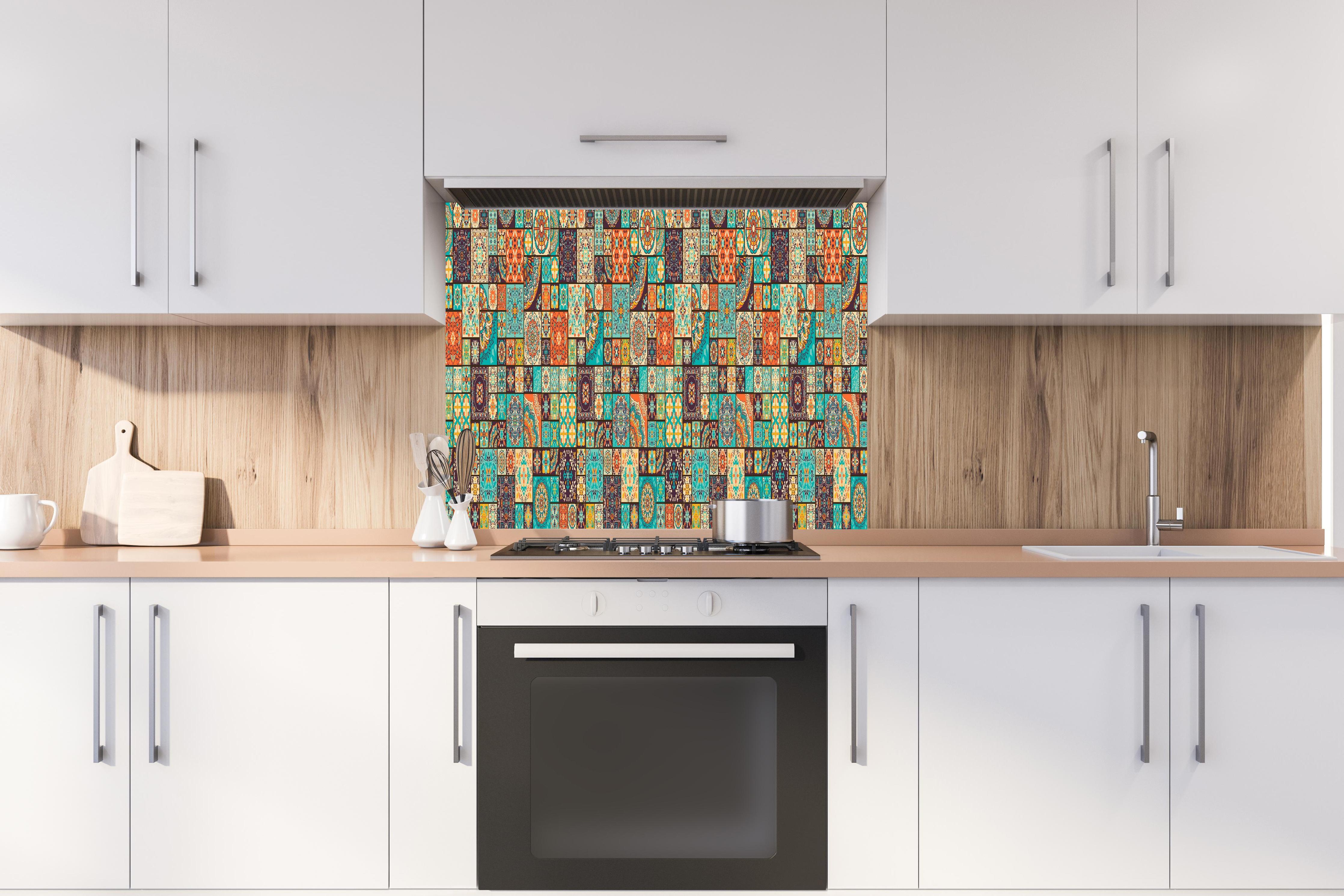 Spritzschutz - Ethnische Muster Vielfalt Farbpracht hinter einem Cerankochfeld zwischen Holz-Kochutensilien
