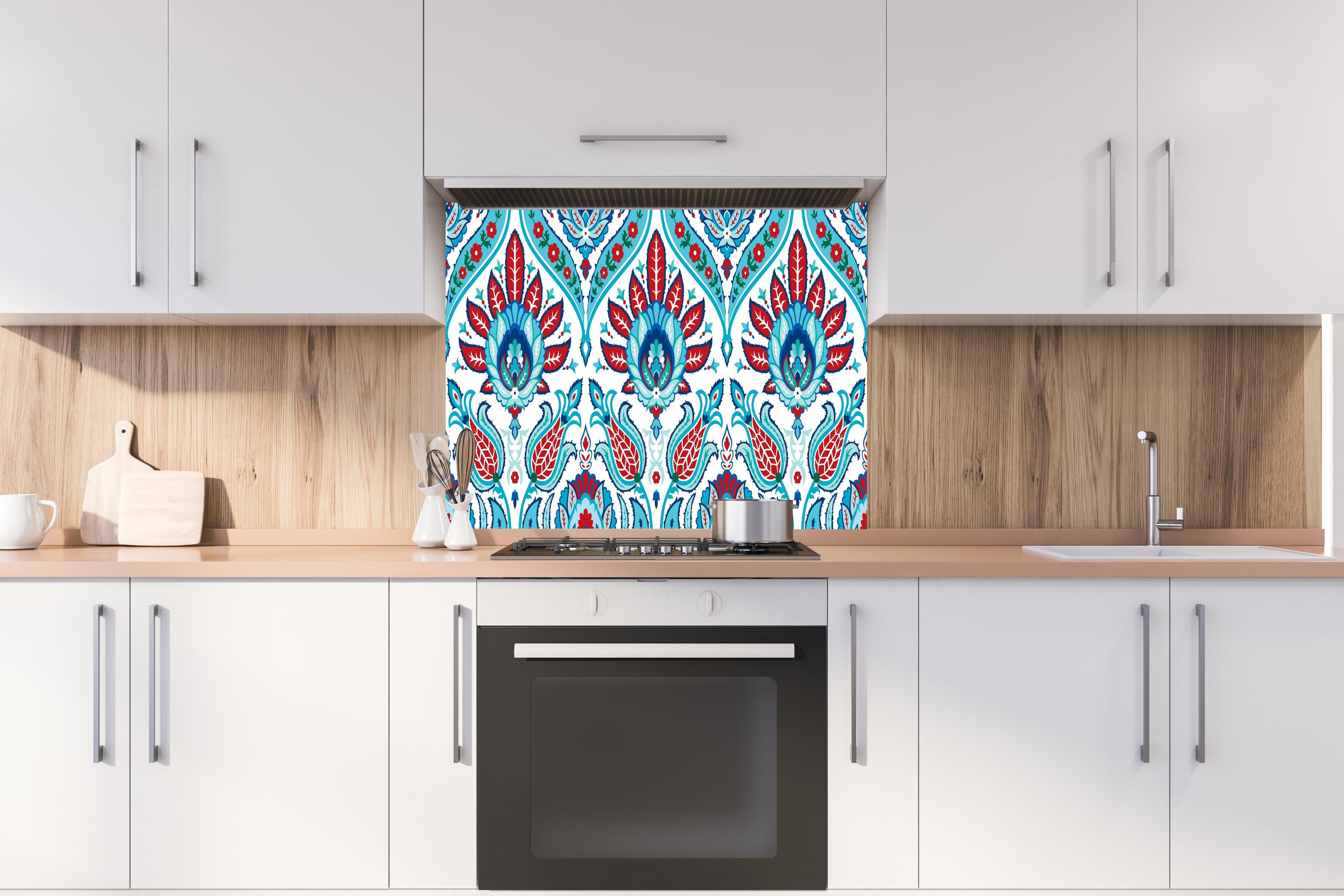 Spritzschutz - Exotisches Türkis-Rotes Paisley-Muster Print hinter einem Cerankochfeld zwischen Holz-Kochutensilien
