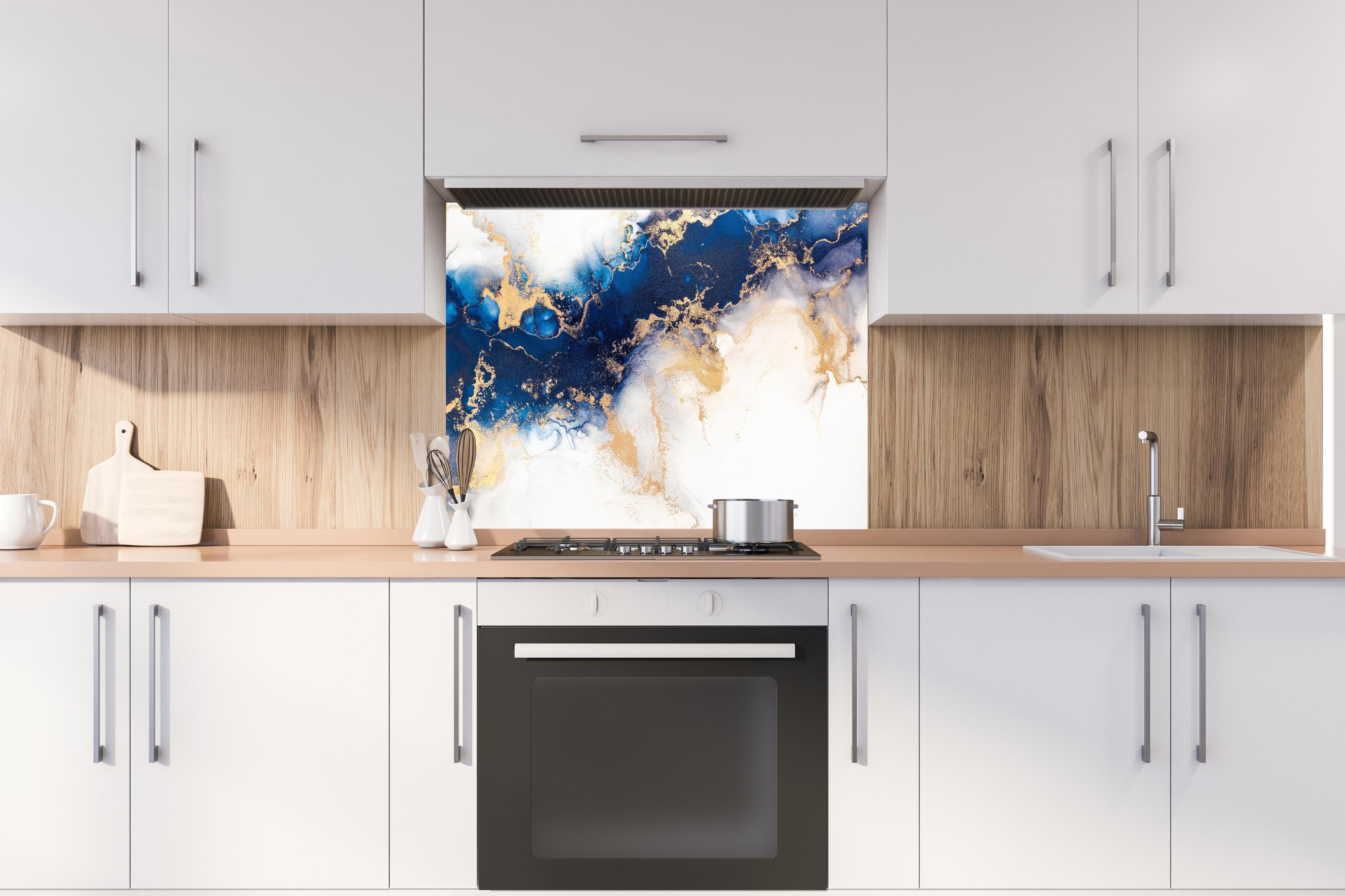 Spritzschutz - Exquisite Marmortinte Kunst in Blau und Gold hinter einem Cerankochfeld zwischen Holz-Kochutensilien
