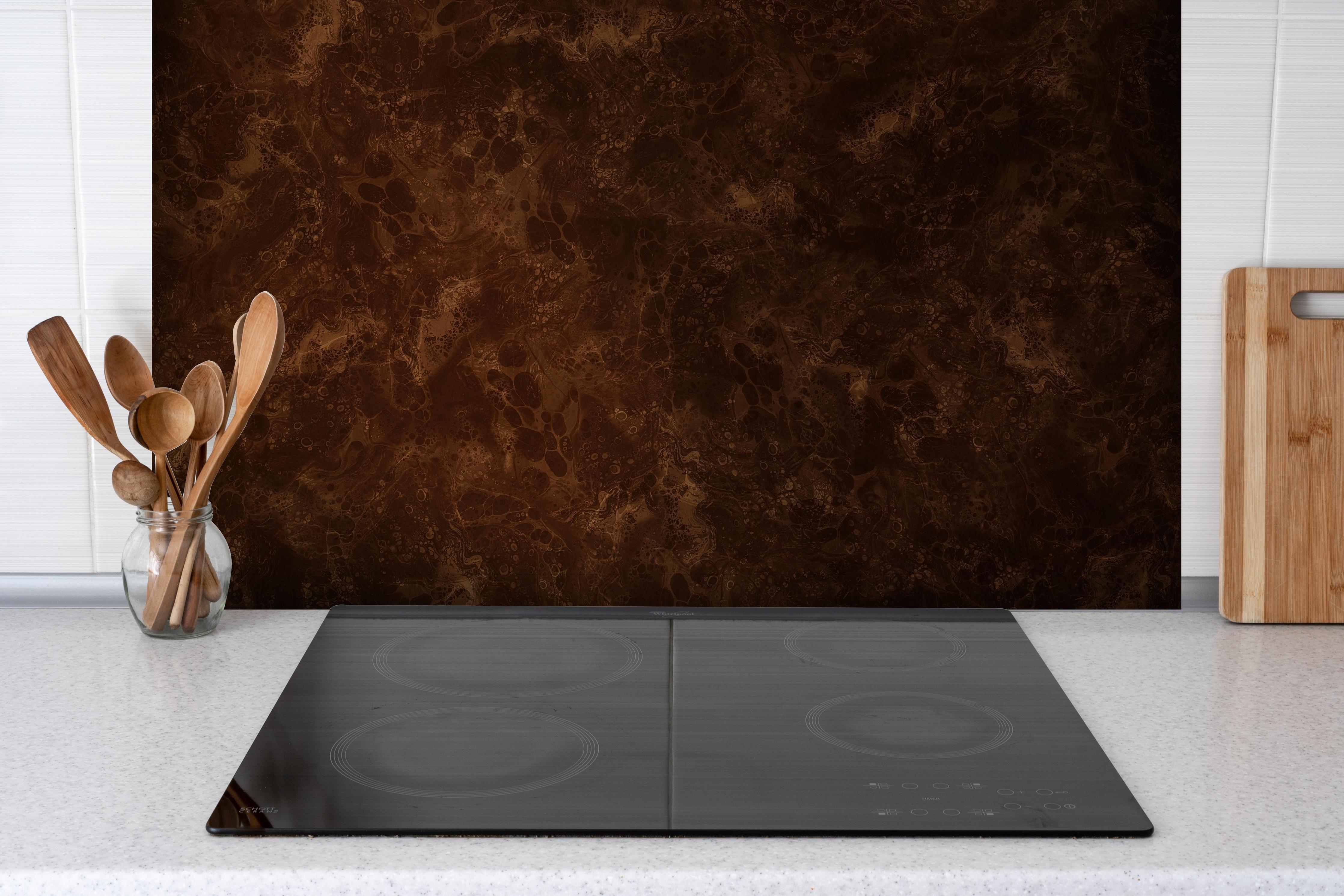 Spritzschutz - Fantasievolle Farbmischung hinter einem Cerankochfeld zwischen Holz-Kochutensilien
