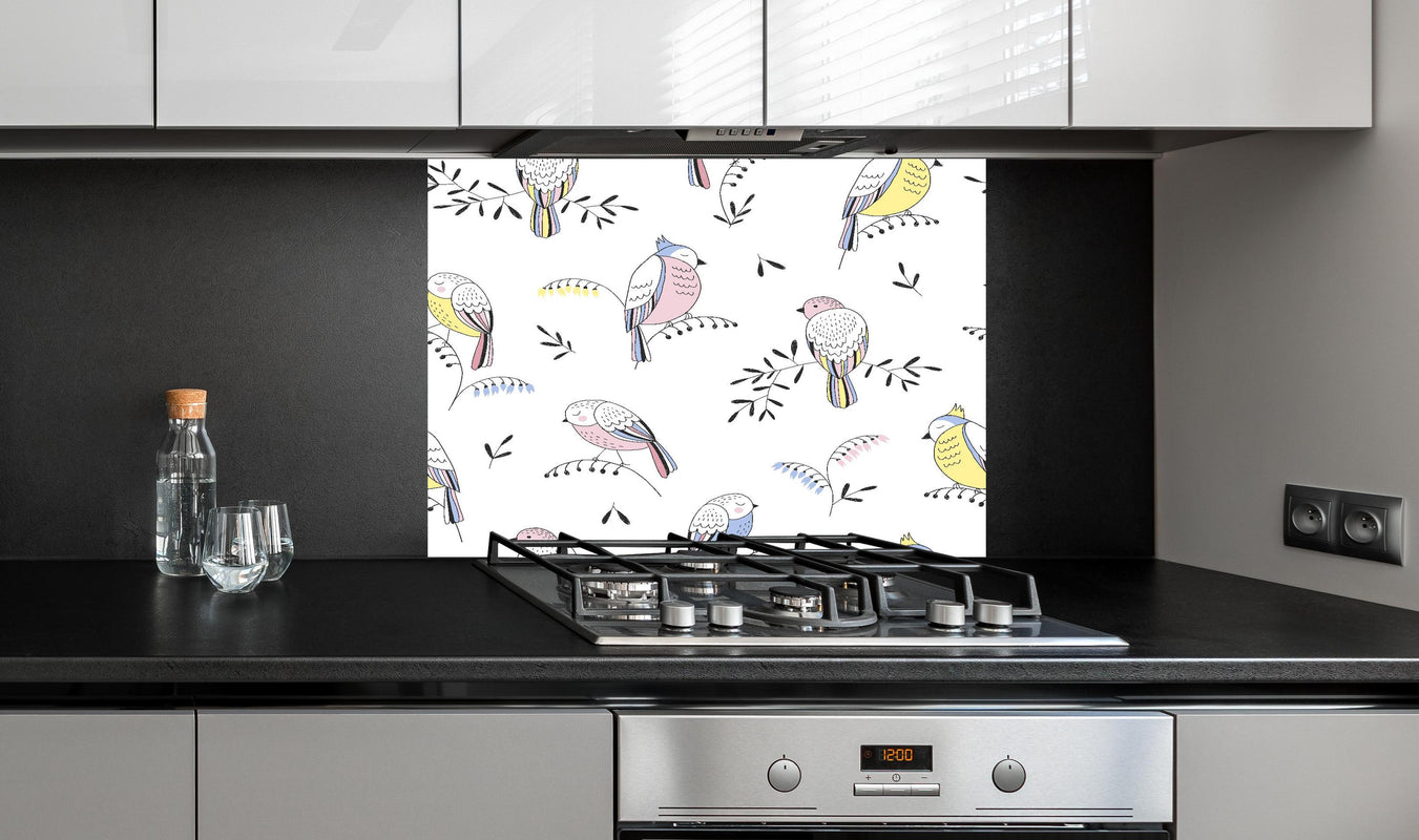Spritzschutz - Farbenfrohes Vogel Muster Design Tapete hinter einem Cerankochfeld zwischen Holz-Kochutensilien
