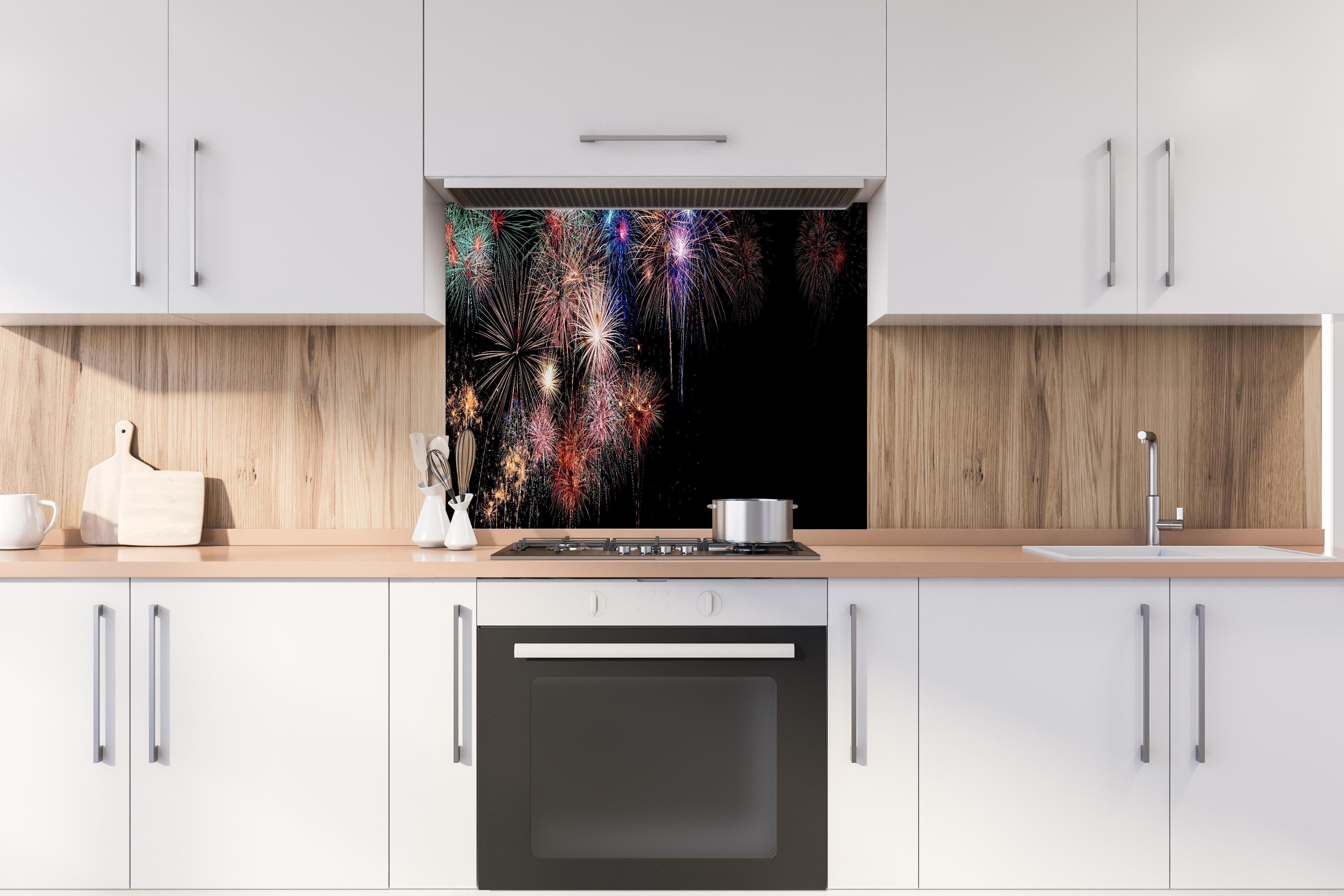 Spritzschutz - Farbenpracht Feuerwerk Happy New Year 2023 hinter einem Cerankochfeld zwischen Holz-Kochutensilien
