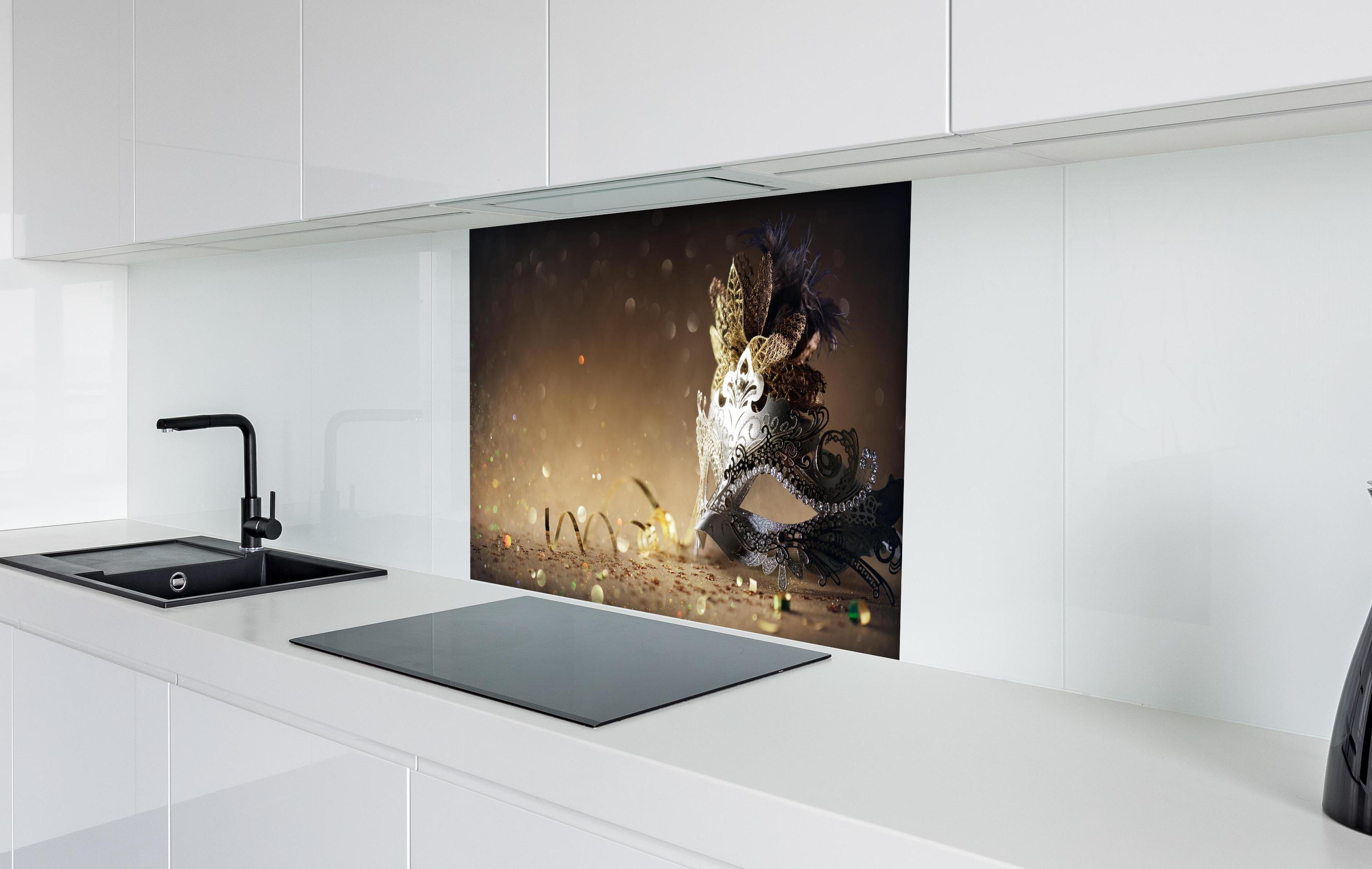 Spritzschutz - Faschingsmaske mit Glitter hinter einem Cerankochfeld zwischen Holz-Kochutensilien
