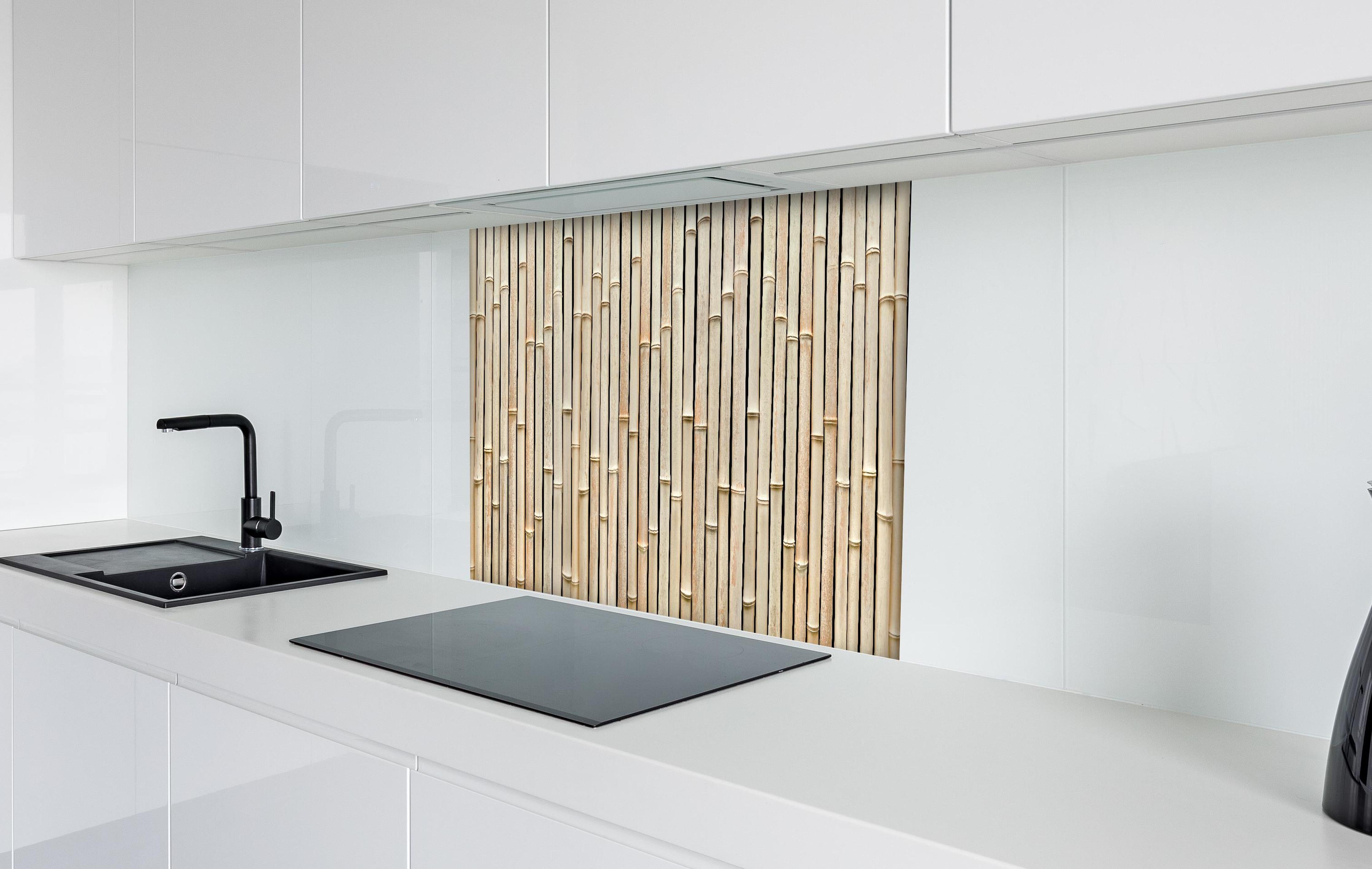 Spritzschutz - Fassade aus schönem Bambus hinter einem Cerankochfeld zwischen Holz-Kochutensilien
