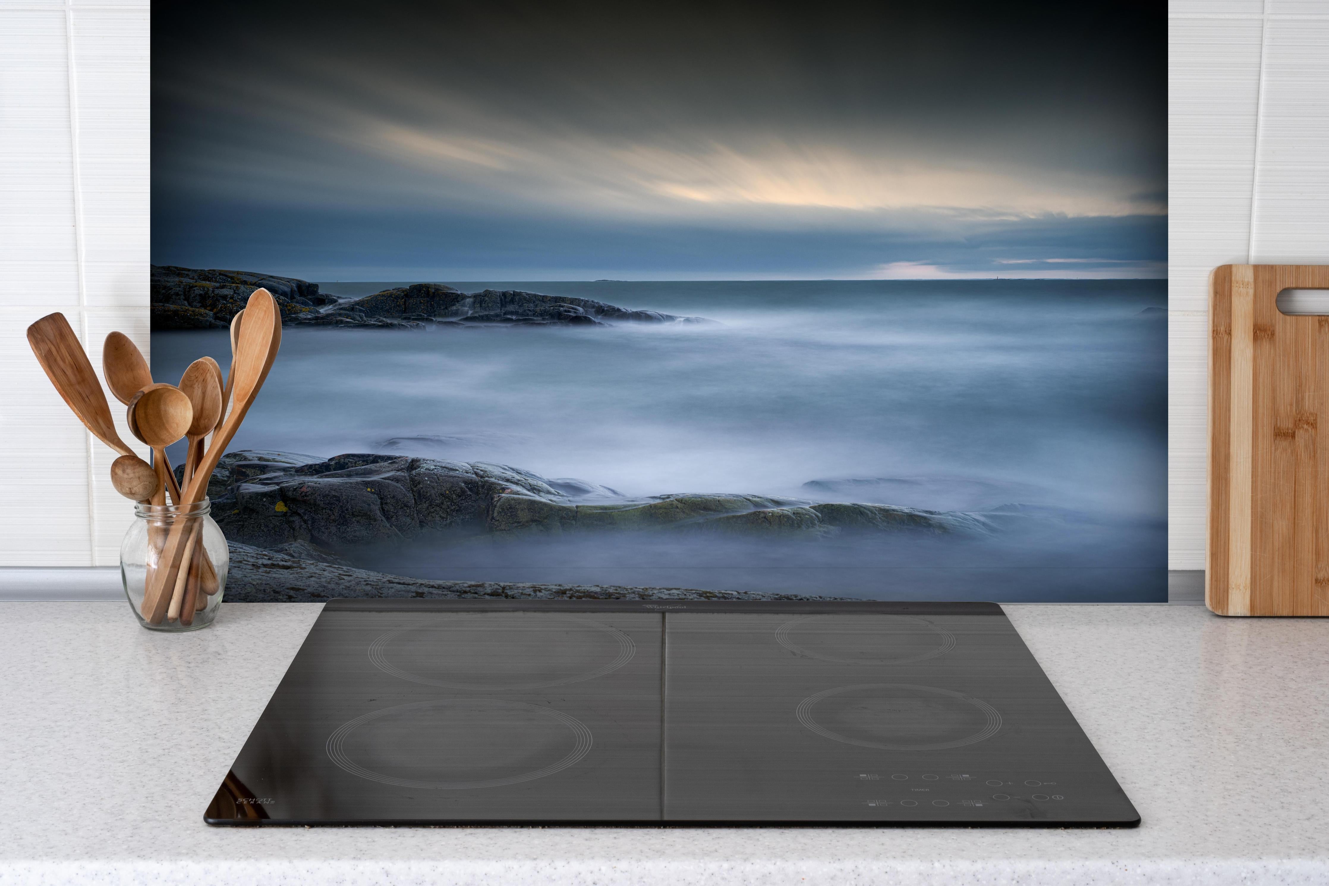 Spritzschutz - Felsiger & Nebliger Strand auf mit schöner Meer Landschaft hinter einem Cerankochfeld zwischen Holz-Kochutensilien
