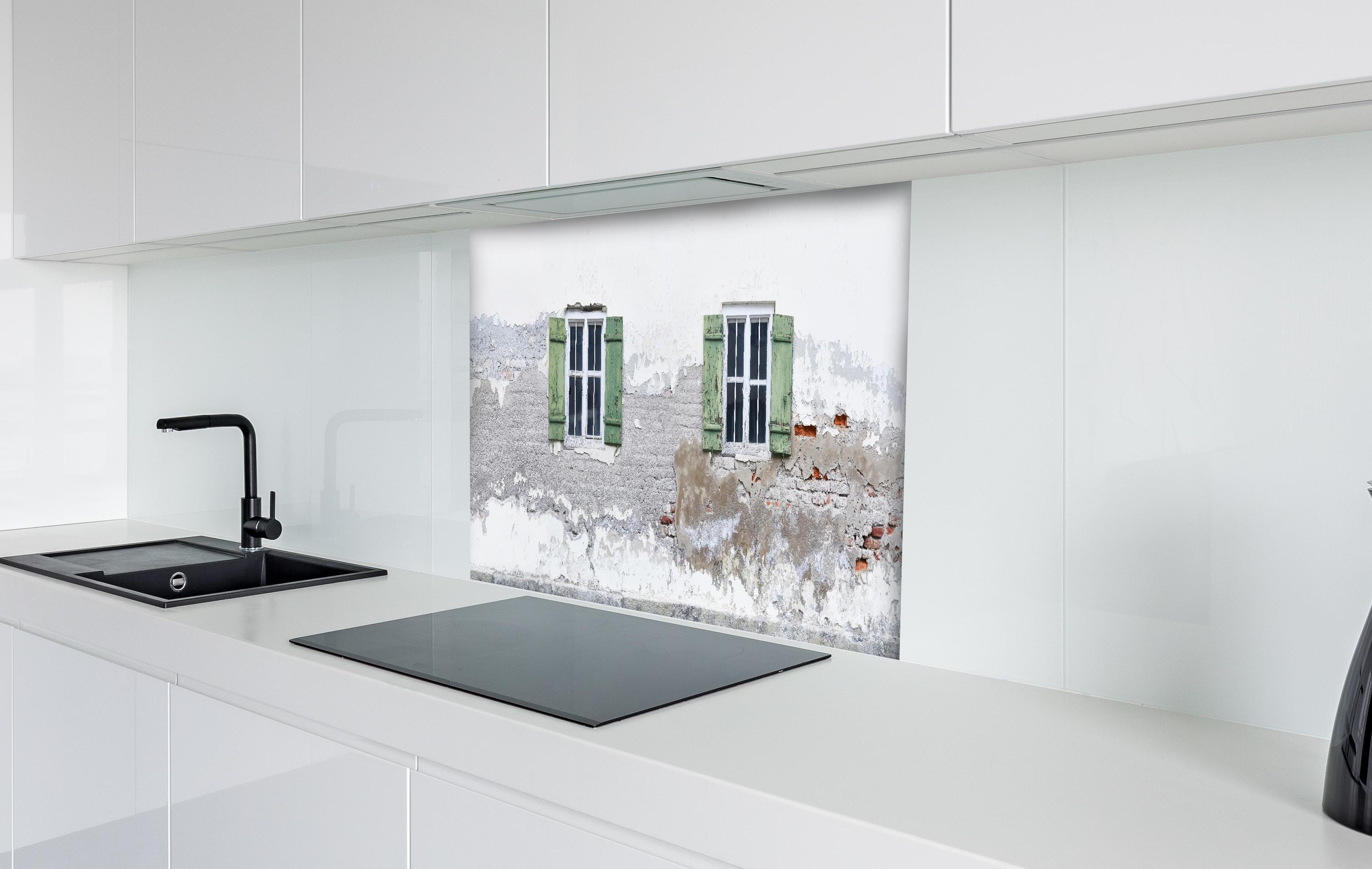 Spritzschutz - Fensterrahmen einer veralteten Hauswand hinter einem Cerankochfeld zwischen Holz-Kochutensilien
