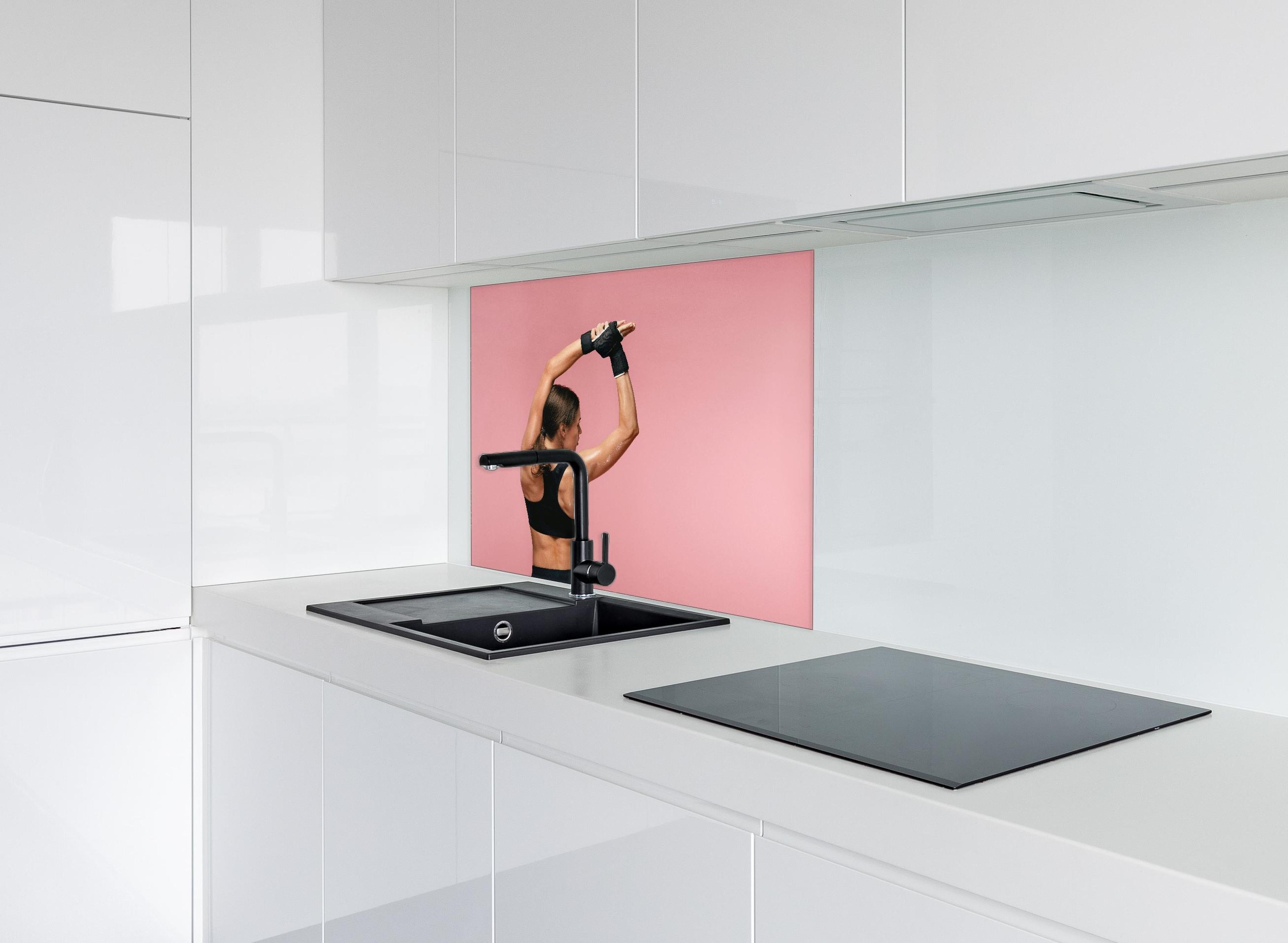 Spritzschutz - Fitness Frau streckt sich vor Training hinter einem Cerankochfeld zwischen Holz-Kochutensilien
