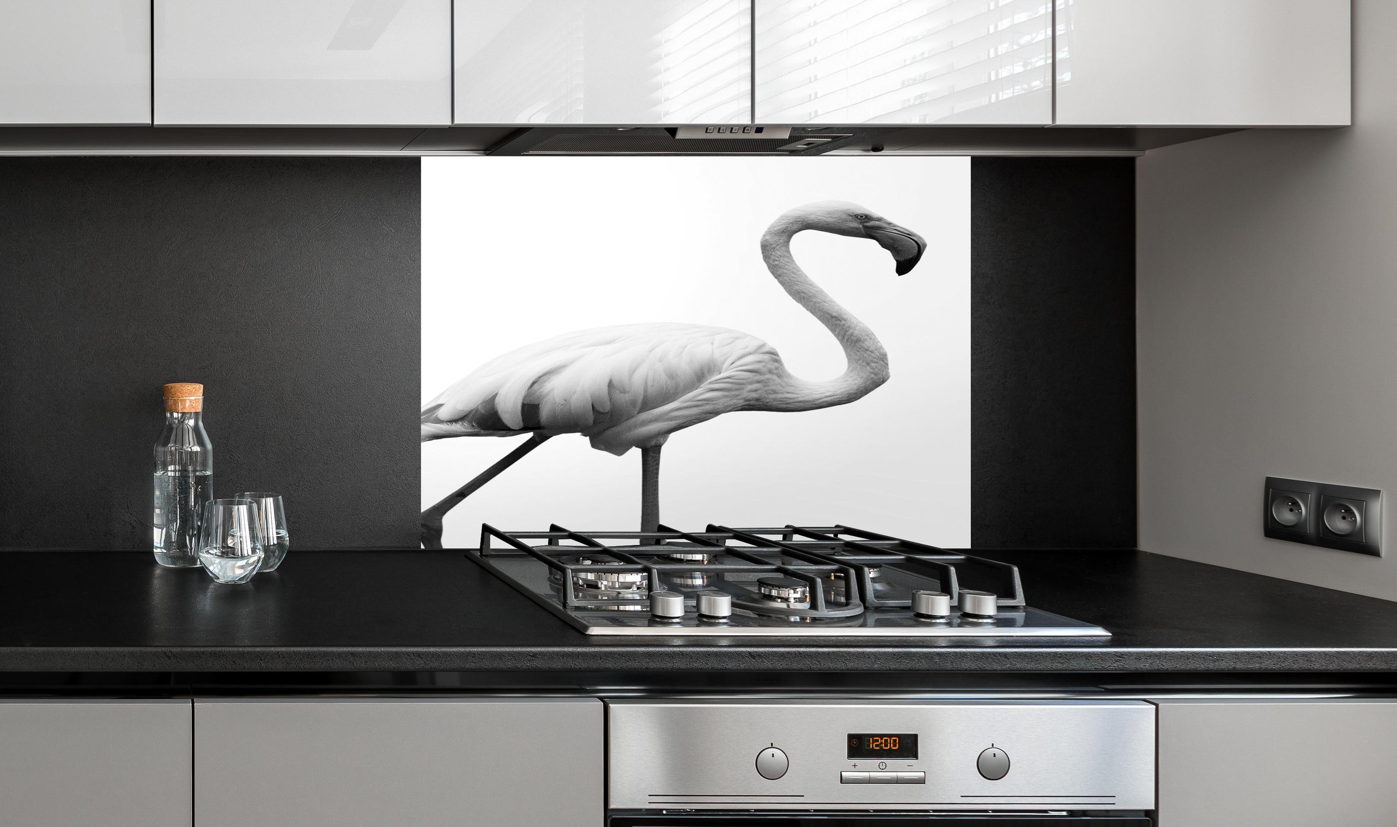 Spritzschutz - Flamingo - schwarz-weiß hinter einem Cerankochfeld zwischen Holz-Kochutensilien
