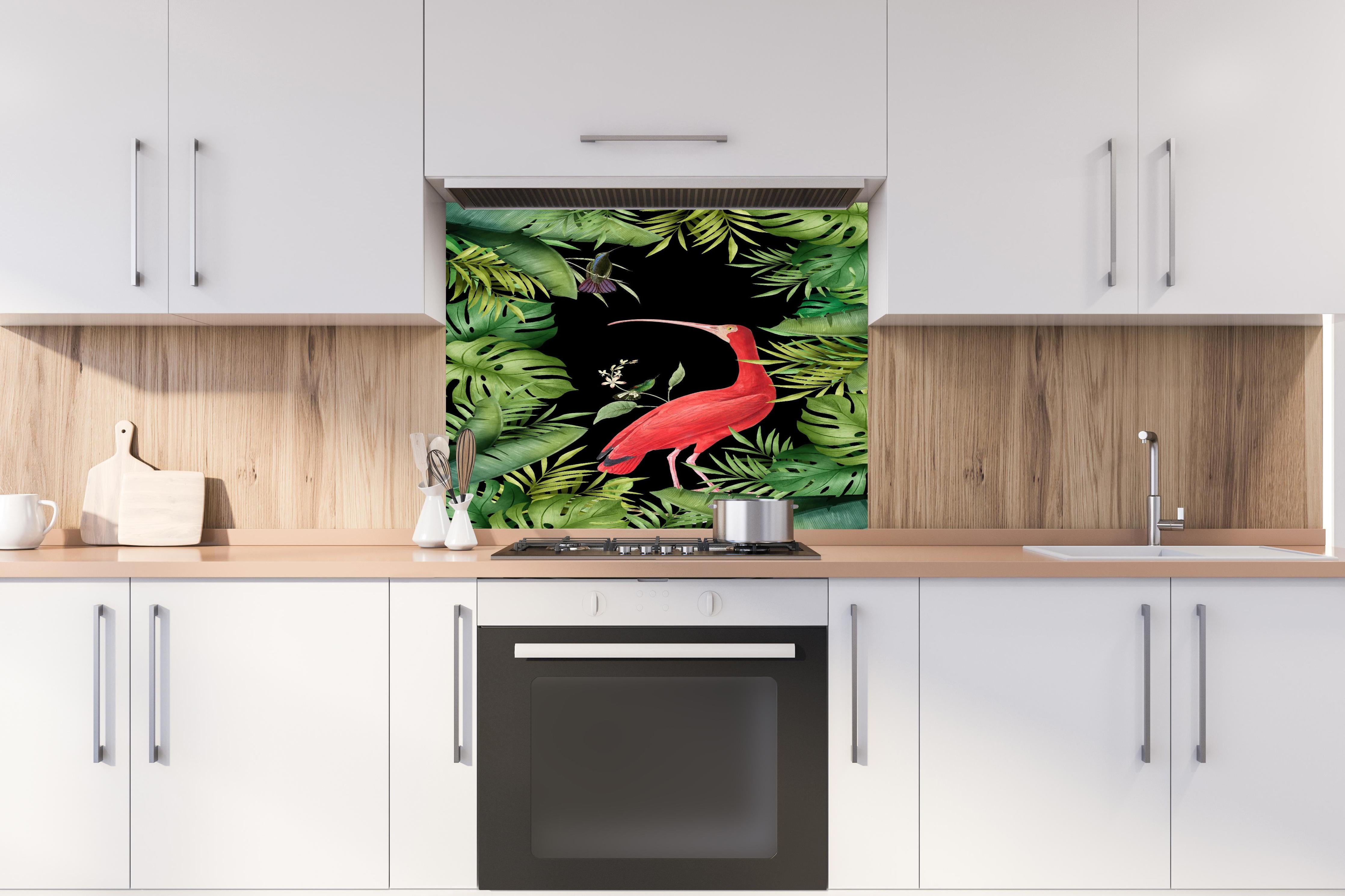 Spritzschutz - Flamingo im Pflanzenrahmen hinter einem Cerankochfeld zwischen Holz-Kochutensilien
