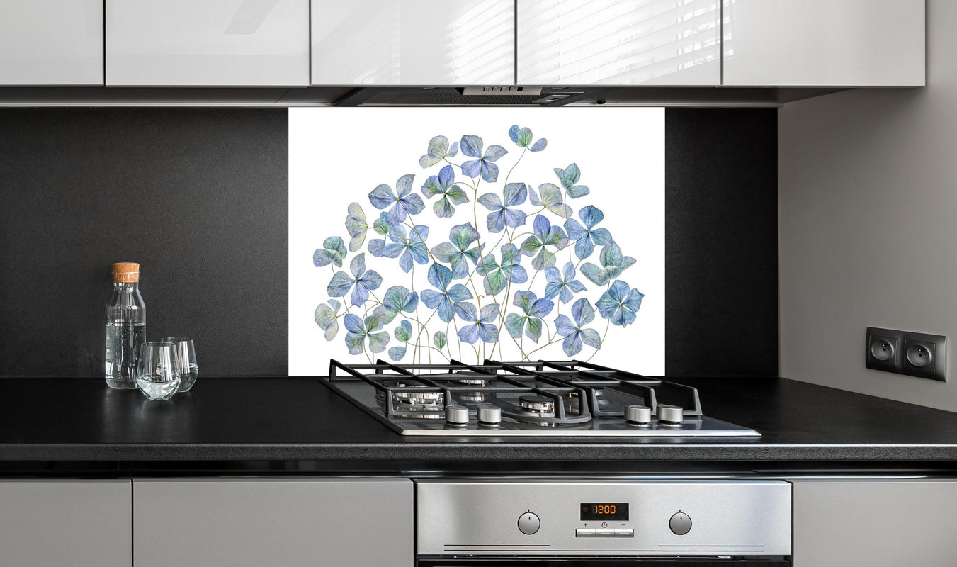 Spritzschutz - Florale Darstellung - Blaue Blumen hinter einem Cerankochfeld zwischen Holz-Kochutensilien
