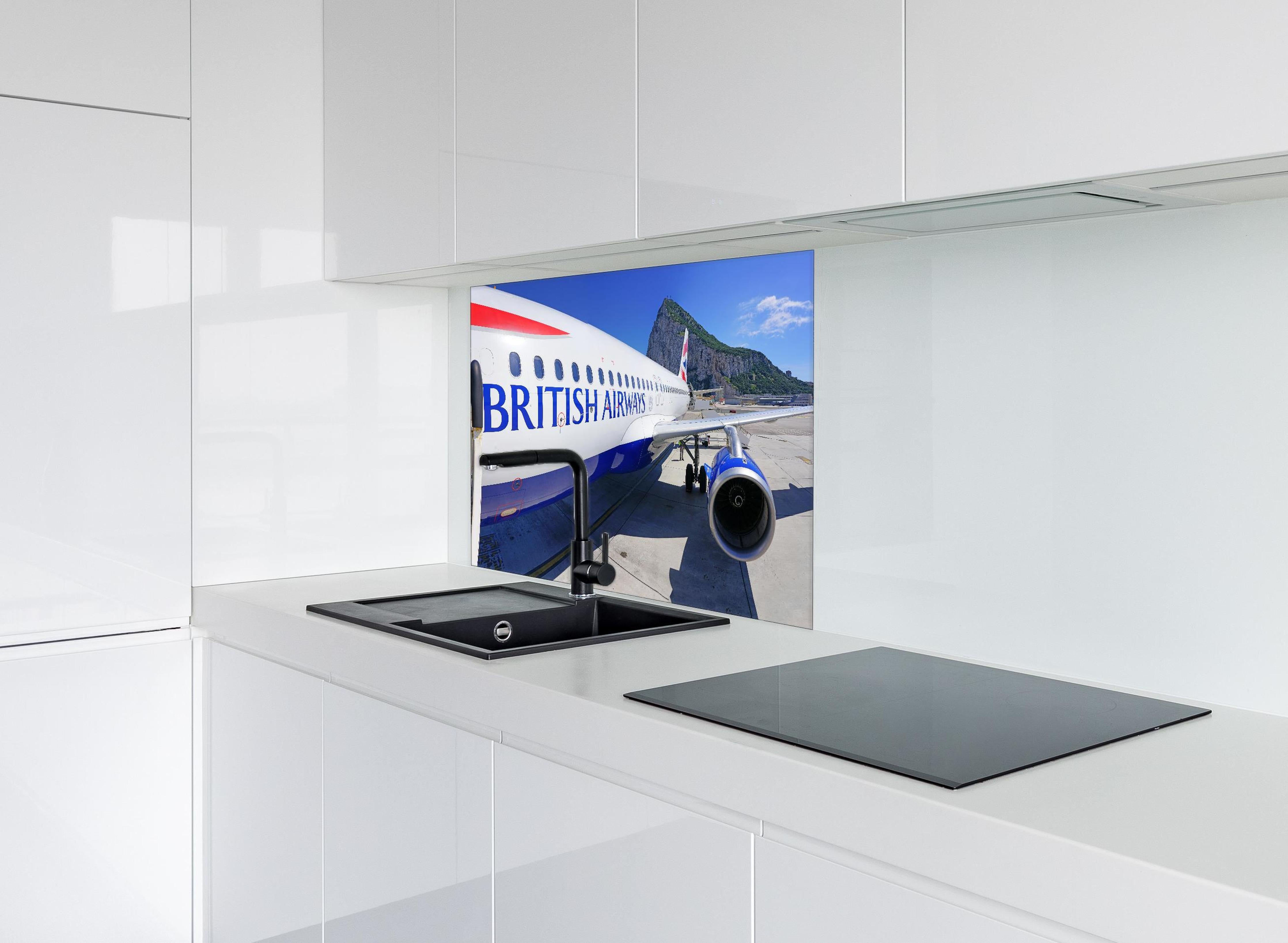 Spritzschutz - Flugzeug von British Airways hinter einem Cerankochfeld zwischen Holz-Kochutensilien
