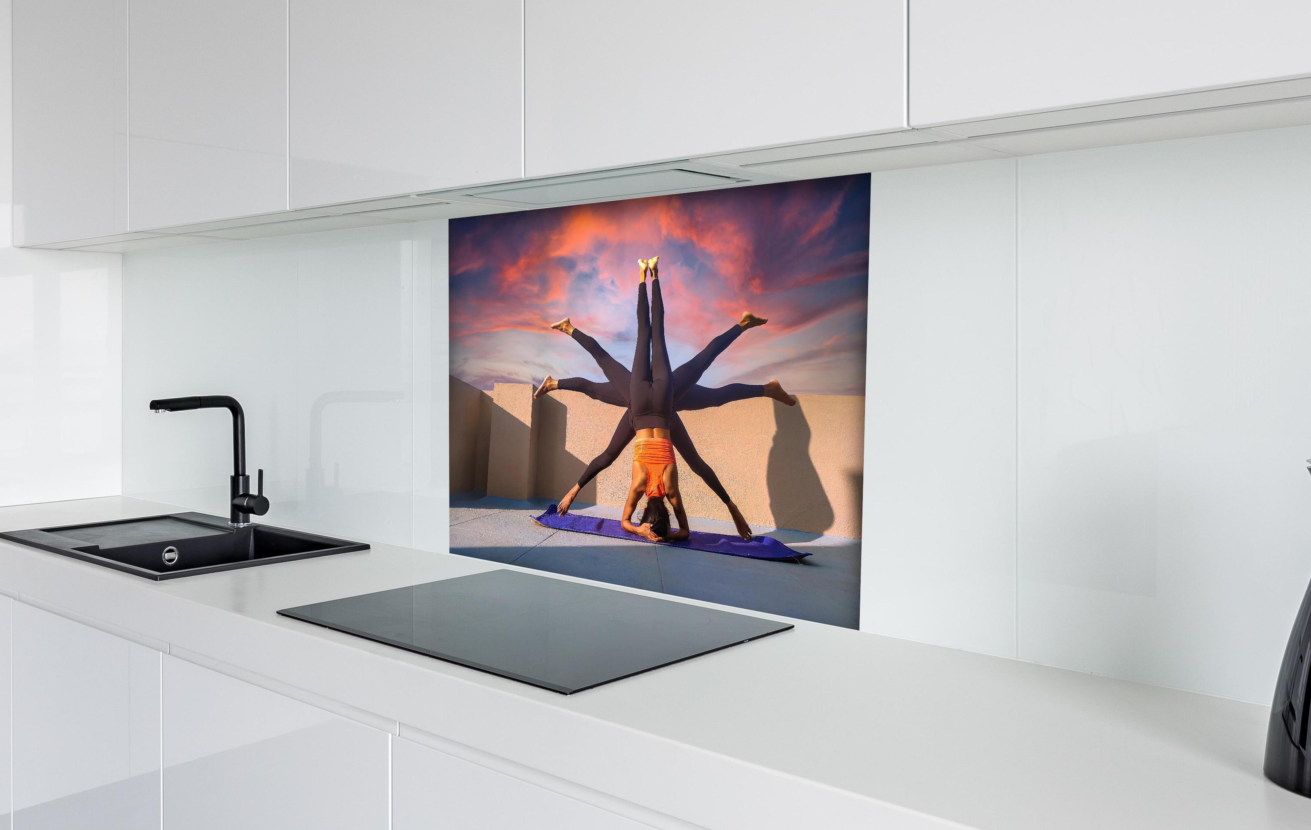 Spritzschutz - Frau Kopfstand verschiedene Posen Spirituell hinter einem Cerankochfeld zwischen Holz-Kochutensilien
