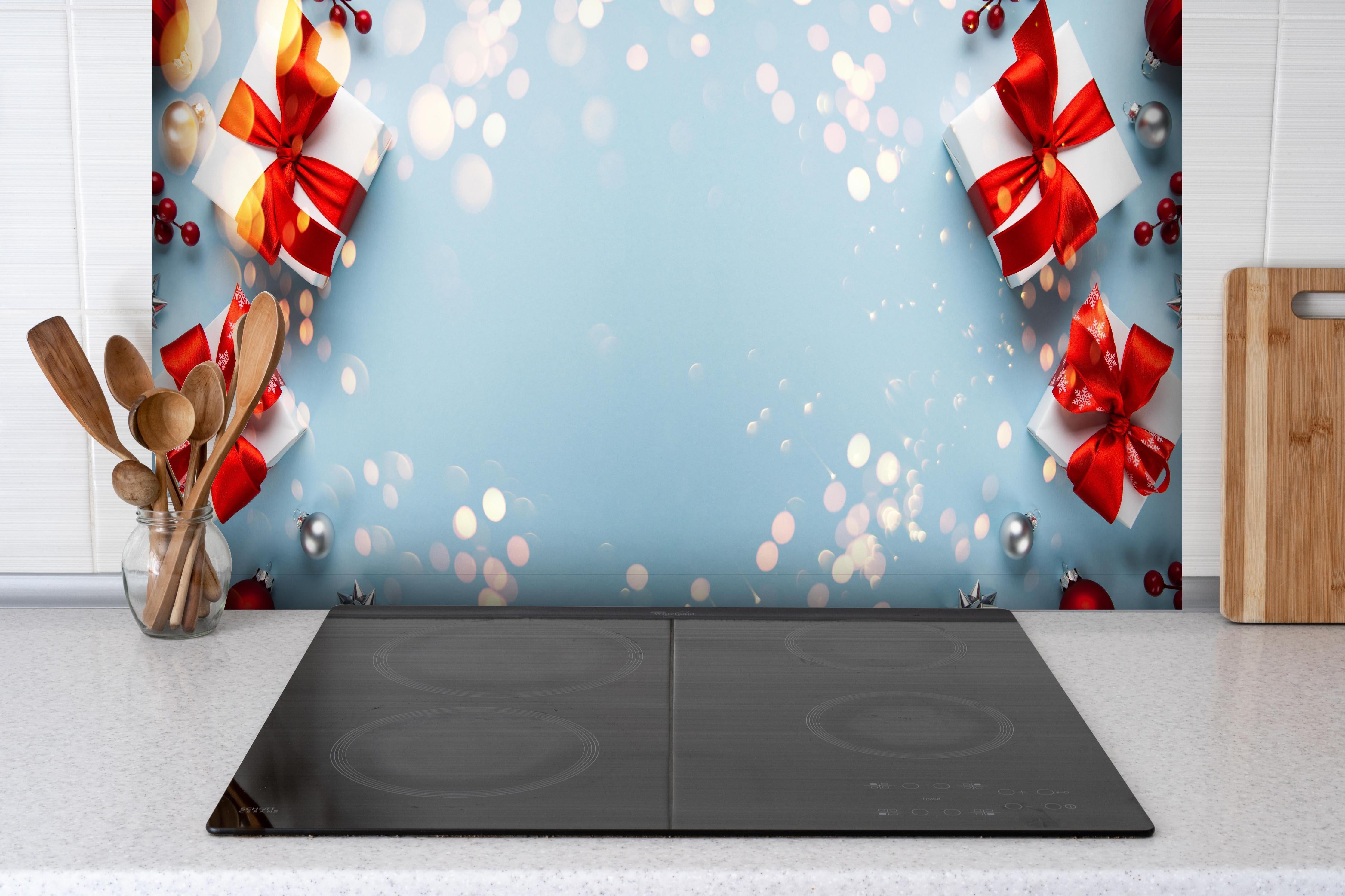 Spritzschutz - Frohe Weihnachten und schöne Feiertage Grußkarte hinter einem Cerankochfeld zwischen Holz-Kochutensilien
