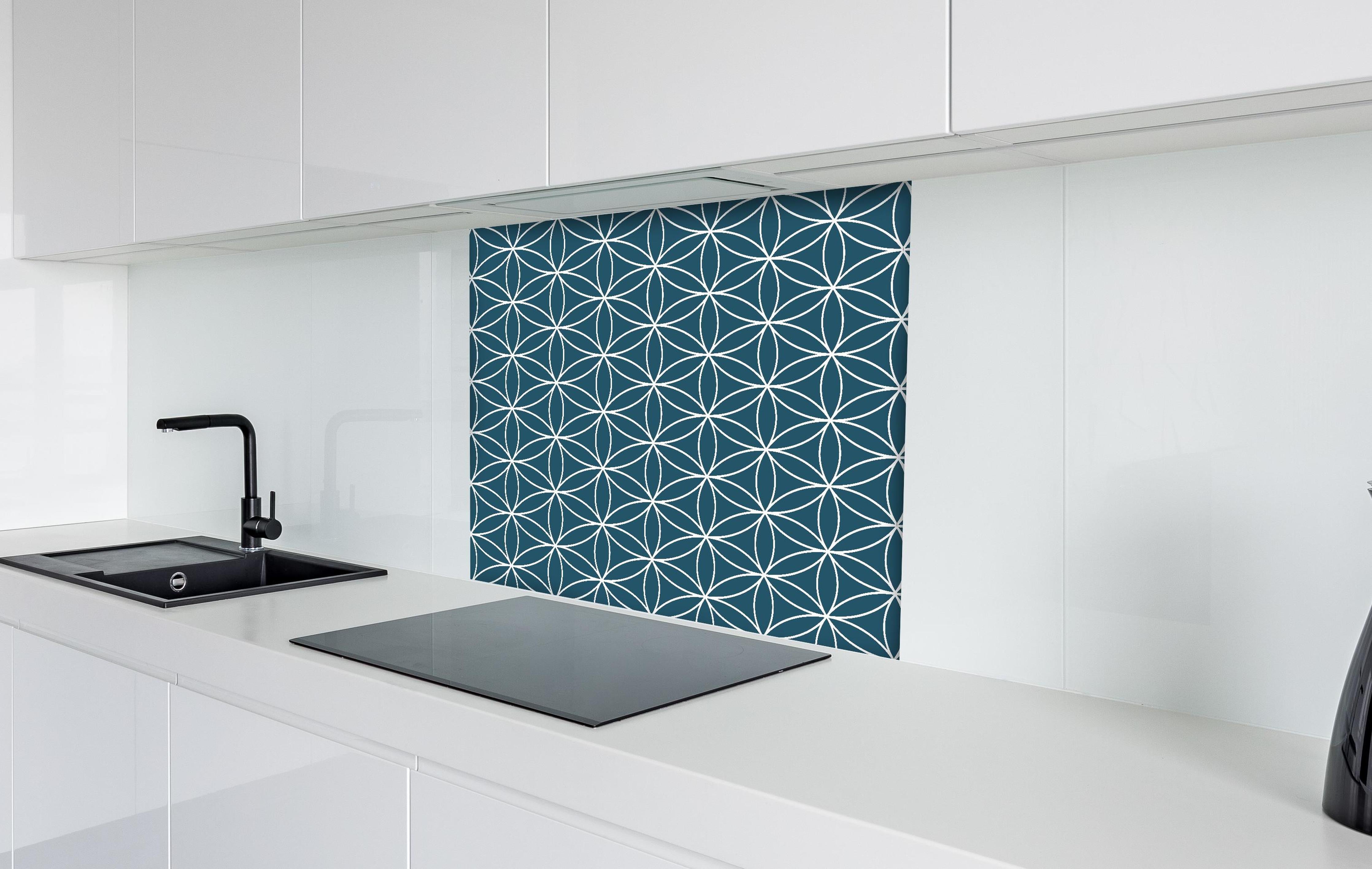 Spritzschutz - Geometrica Fiori Blu Petrolio hinter einem Cerankochfeld zwischen Holz-Kochutensilien
