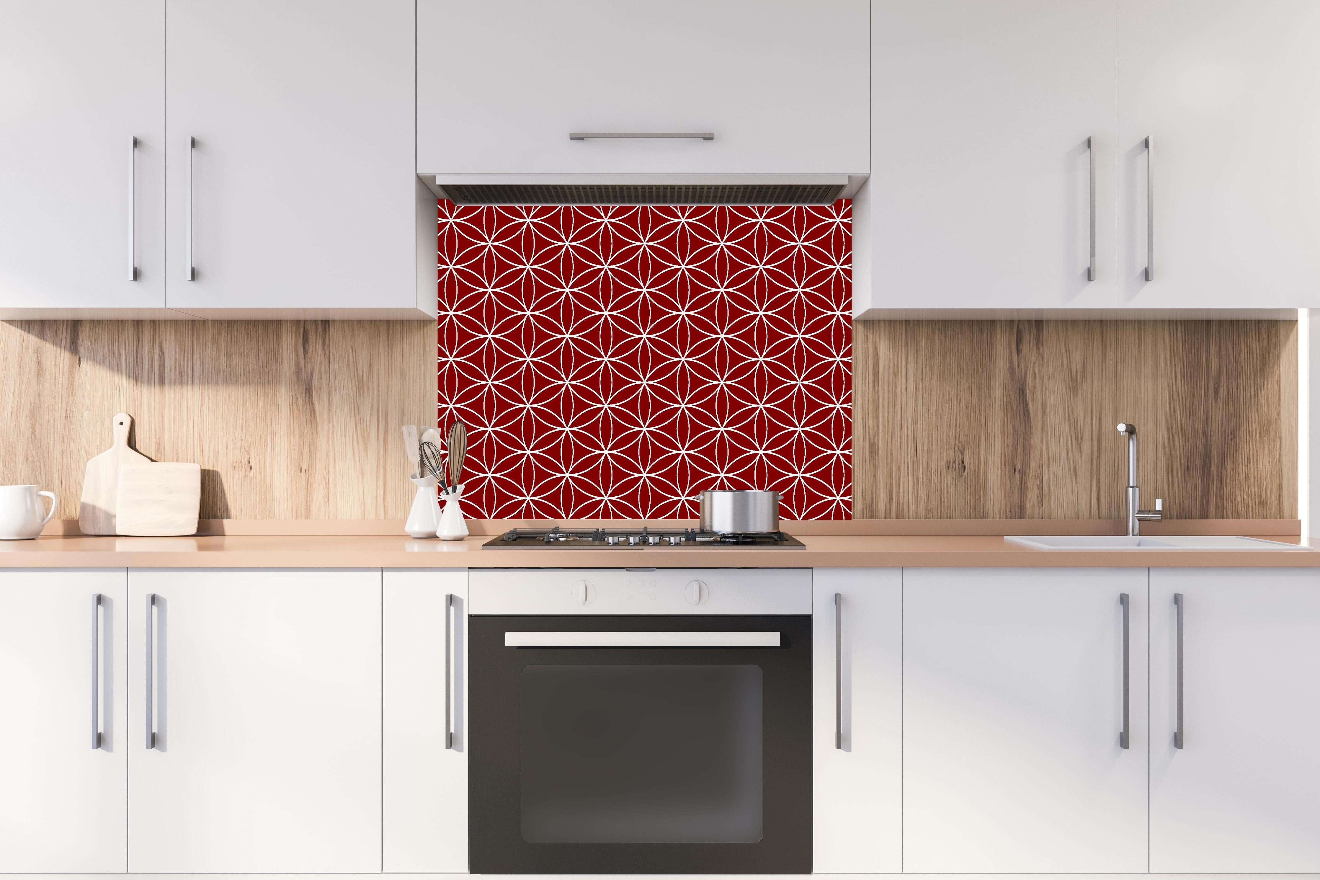 Spritzschutz - Geometrica Fiori Granata hinter einem Cerankochfeld zwischen Holz-Kochutensilien
