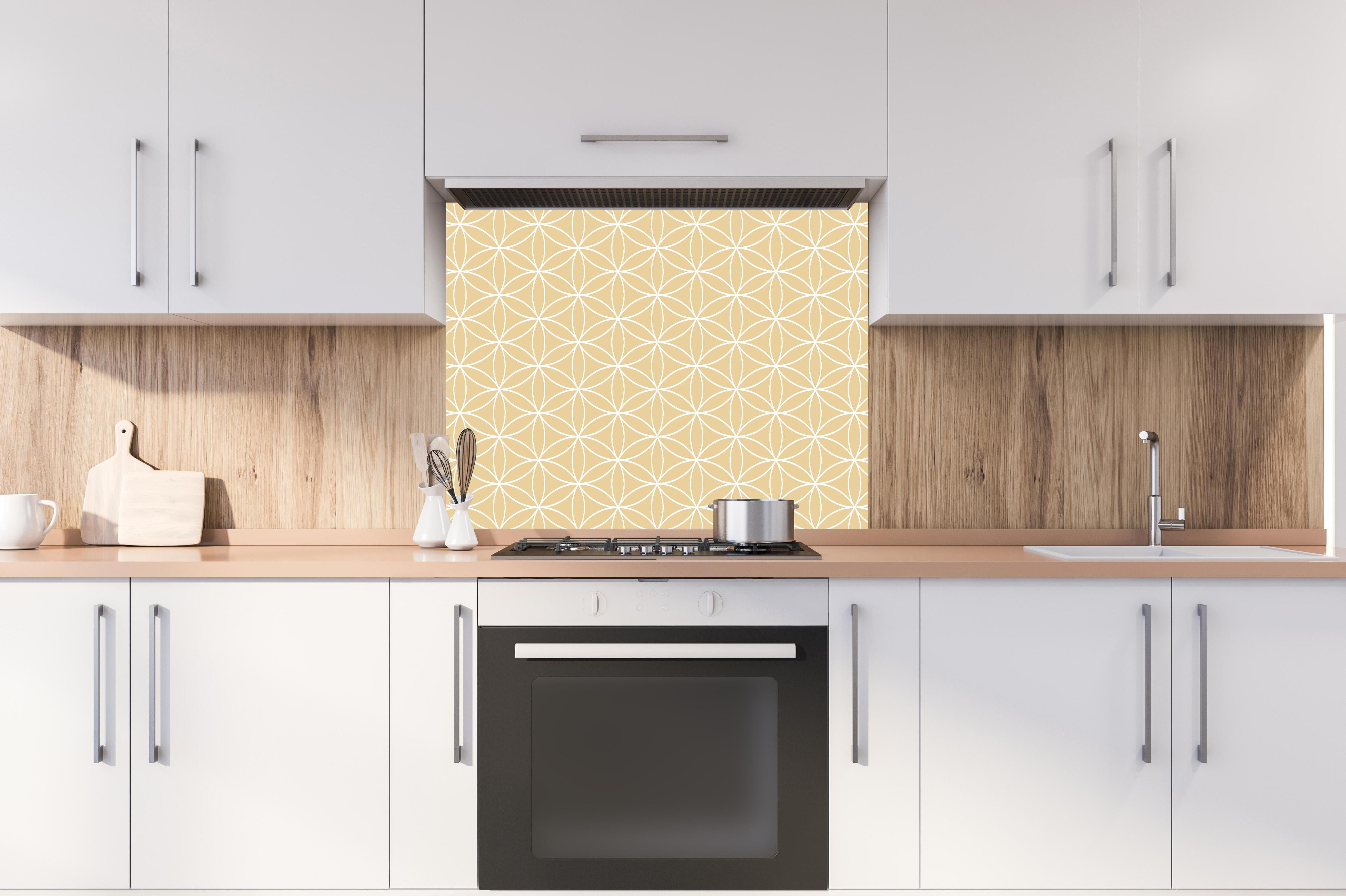 Spritzschutz - Geometrica Fiori Sabbia hinter einem Cerankochfeld zwischen Holz-Kochutensilien
