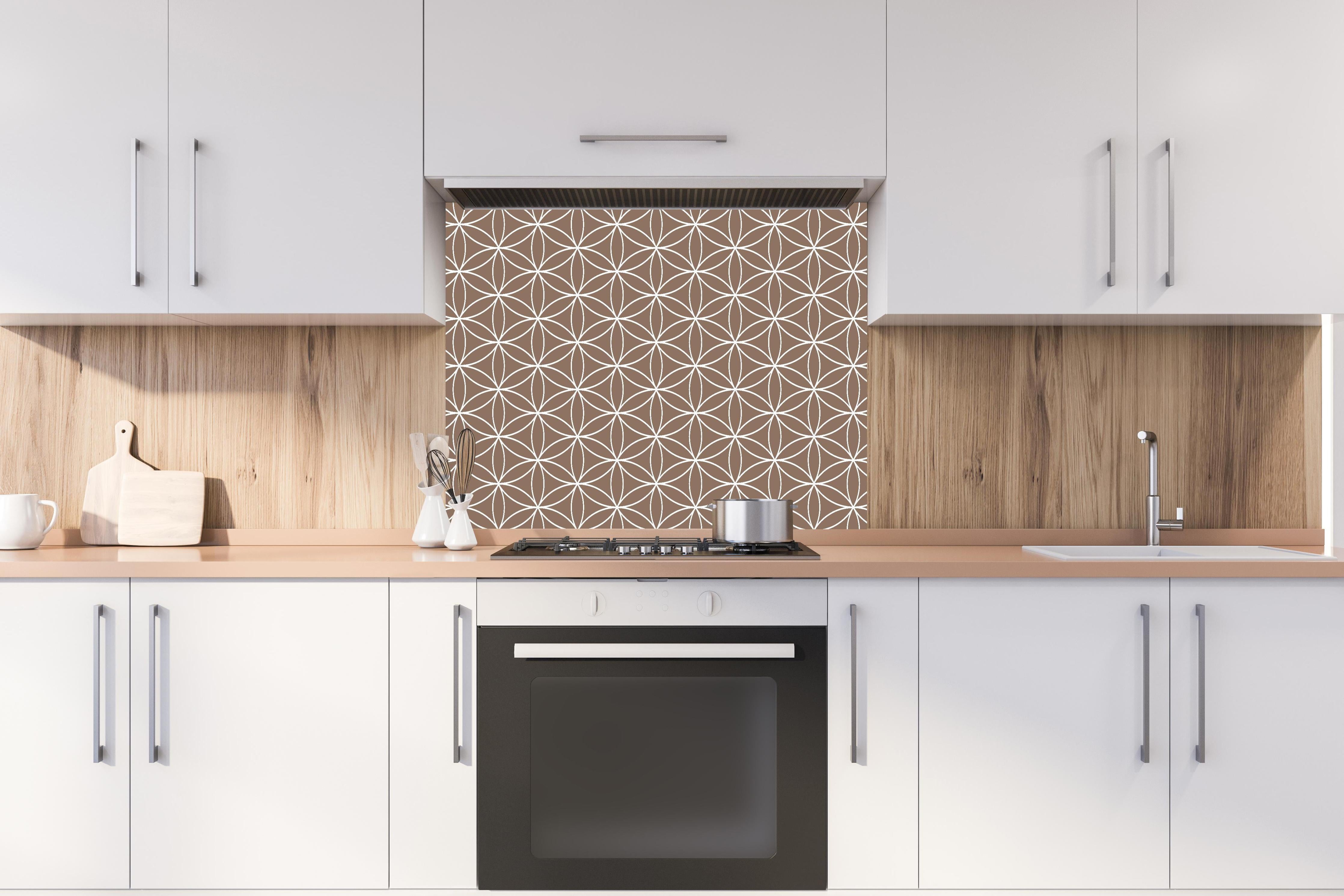 Spritzschutz - Geometrica Fiori Sigaro hinter einem Cerankochfeld zwischen Holz-Kochutensilien
