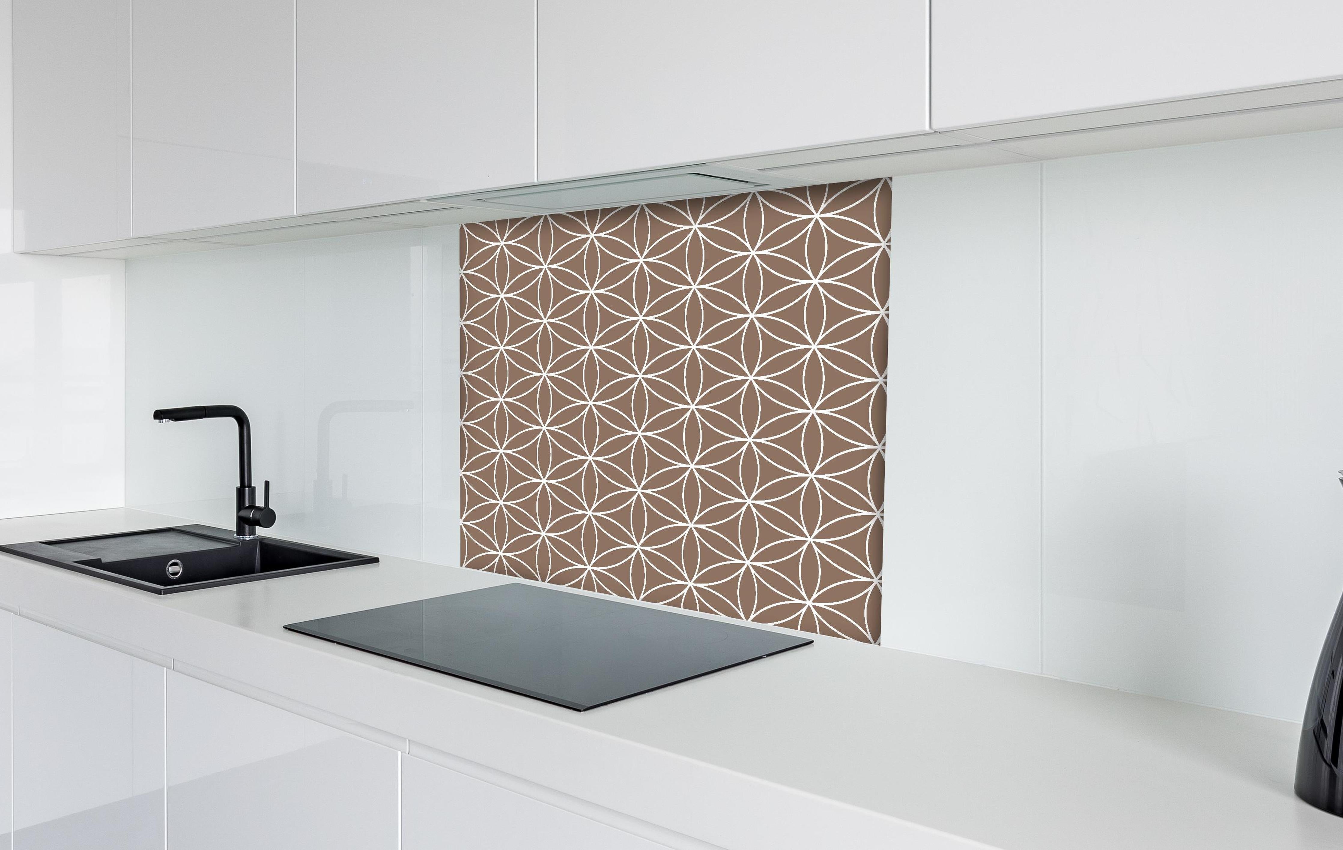 Spritzschutz - Geometrica Fiori Sigaro hinter einem Cerankochfeld zwischen Holz-Kochutensilien
