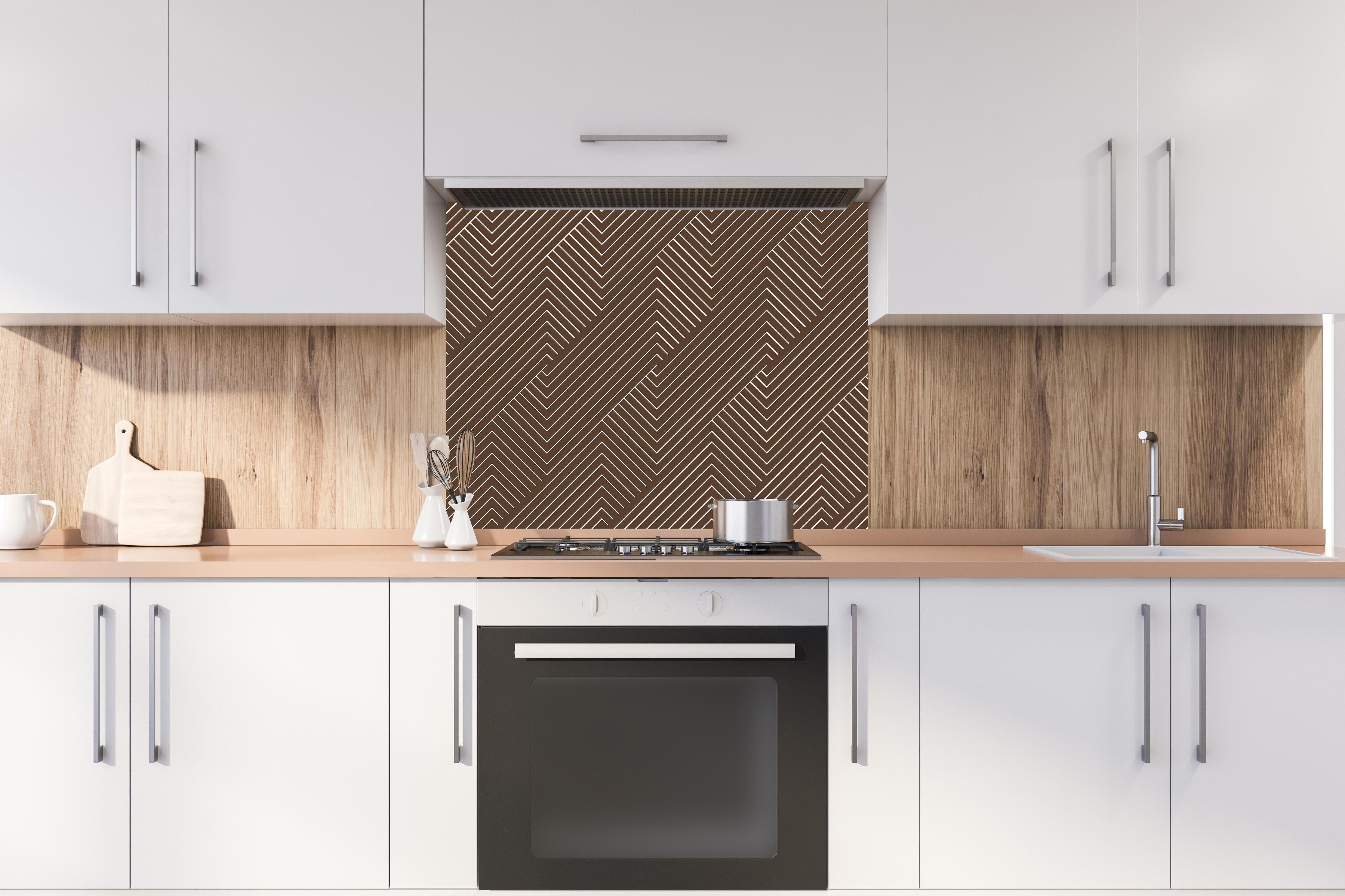 Spritzschutz - Geometrica Intreccio Caffè hinter einem Cerankochfeld zwischen Holz-Kochutensilien
