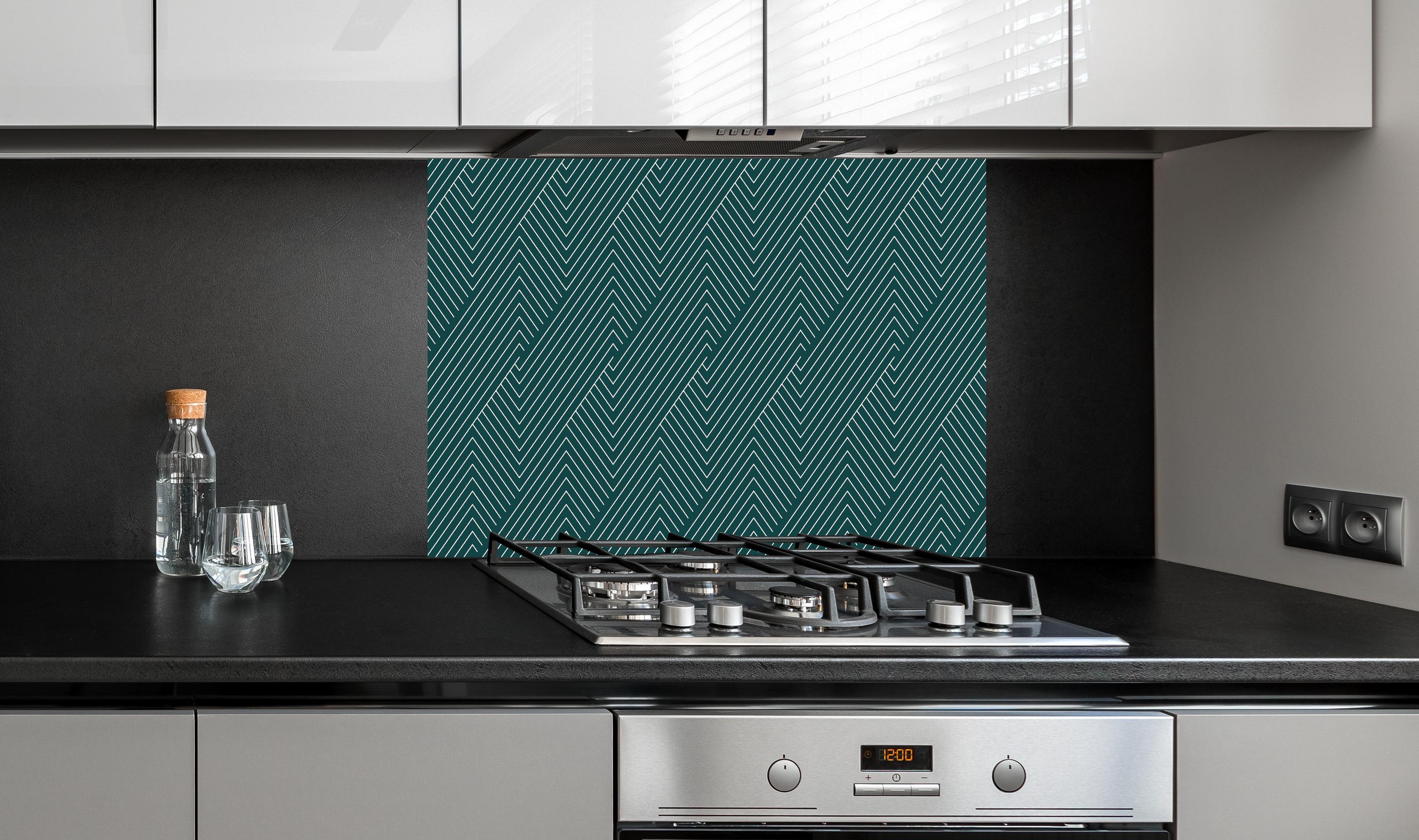 Spritzschutz - Geometrica Intreccio Verde petrolio hinter einem Cerankochfeld zwischen Holz-Kochutensilien
