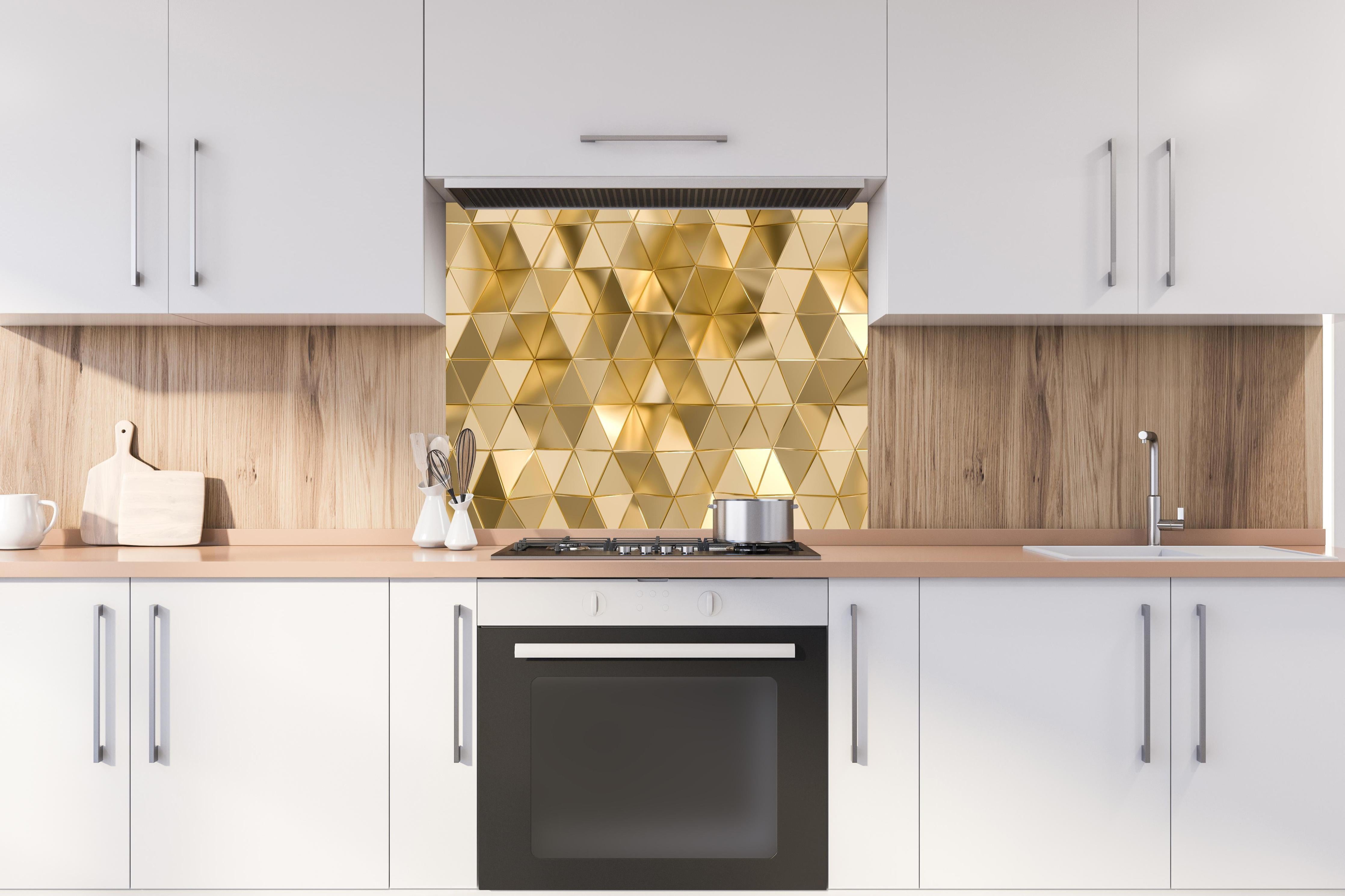 Spritzschutz - Geometrisches Gold Dreieck Polygon-Design hinter einem Cerankochfeld zwischen Holz-Kochutensilien
