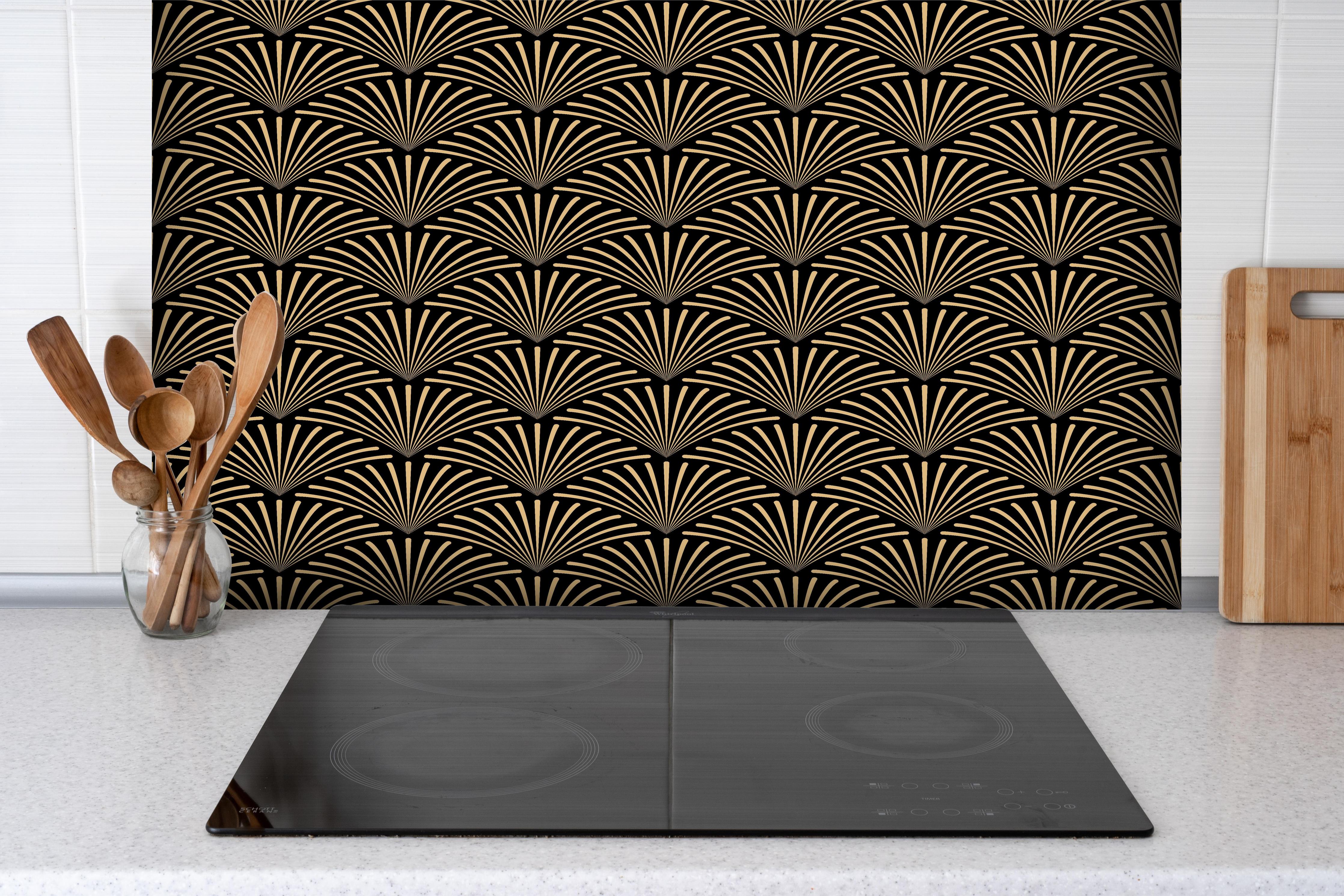Spritzschutz - Geometrisches Gold-Schwarzes Art Déco Design hinter einem Cerankochfeld zwischen Holz-Kochutensilien
