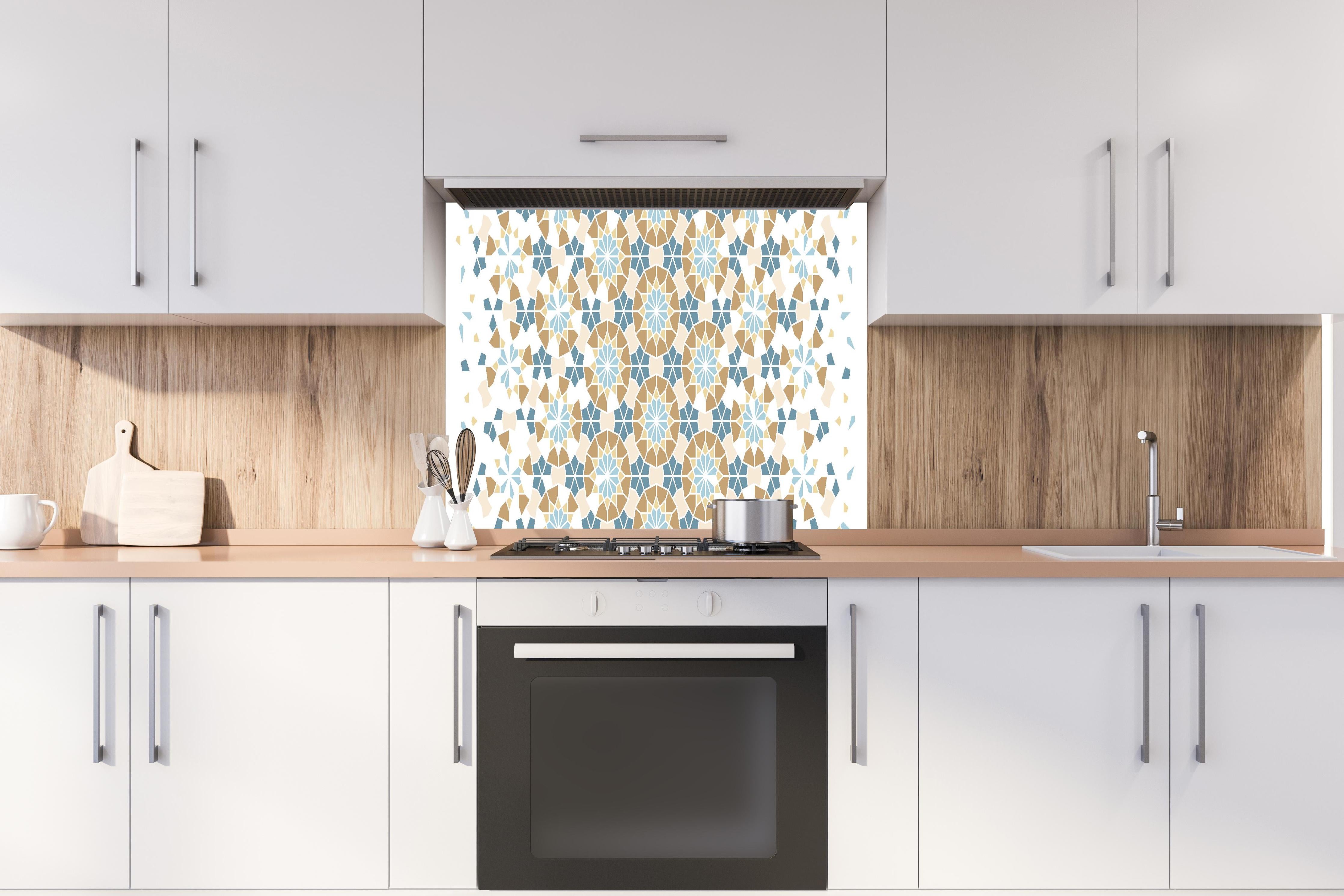 Spritzschutz - Geometrisches Muster in Blau und Beige hinter einem Cerankochfeld zwischen Holz-Kochutensilien
