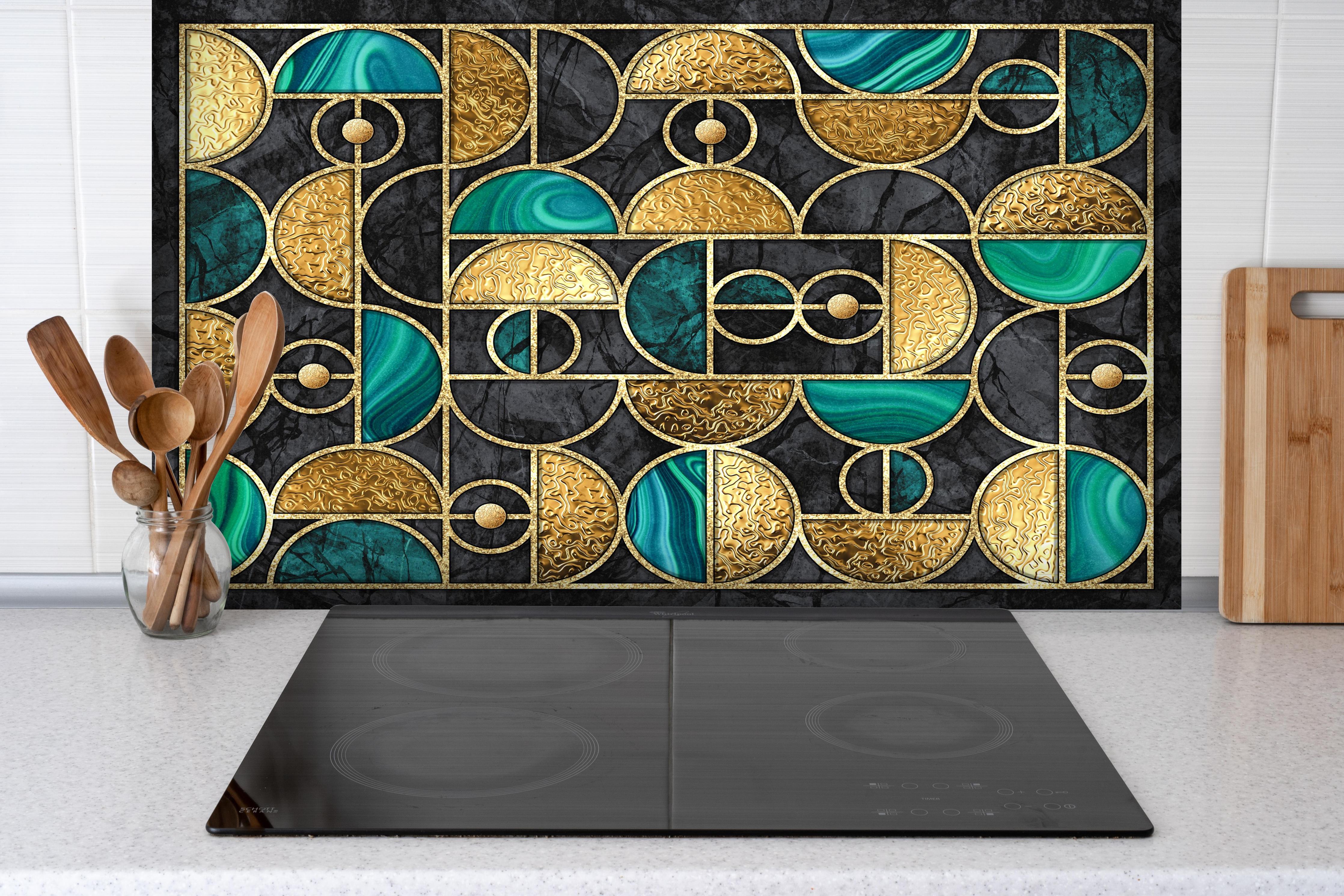 Spritzschutz - Geometrisches Schwarz-Gold-Grün Ringmosaik hinter einem Cerankochfeld zwischen Holz-Kochutensilien
