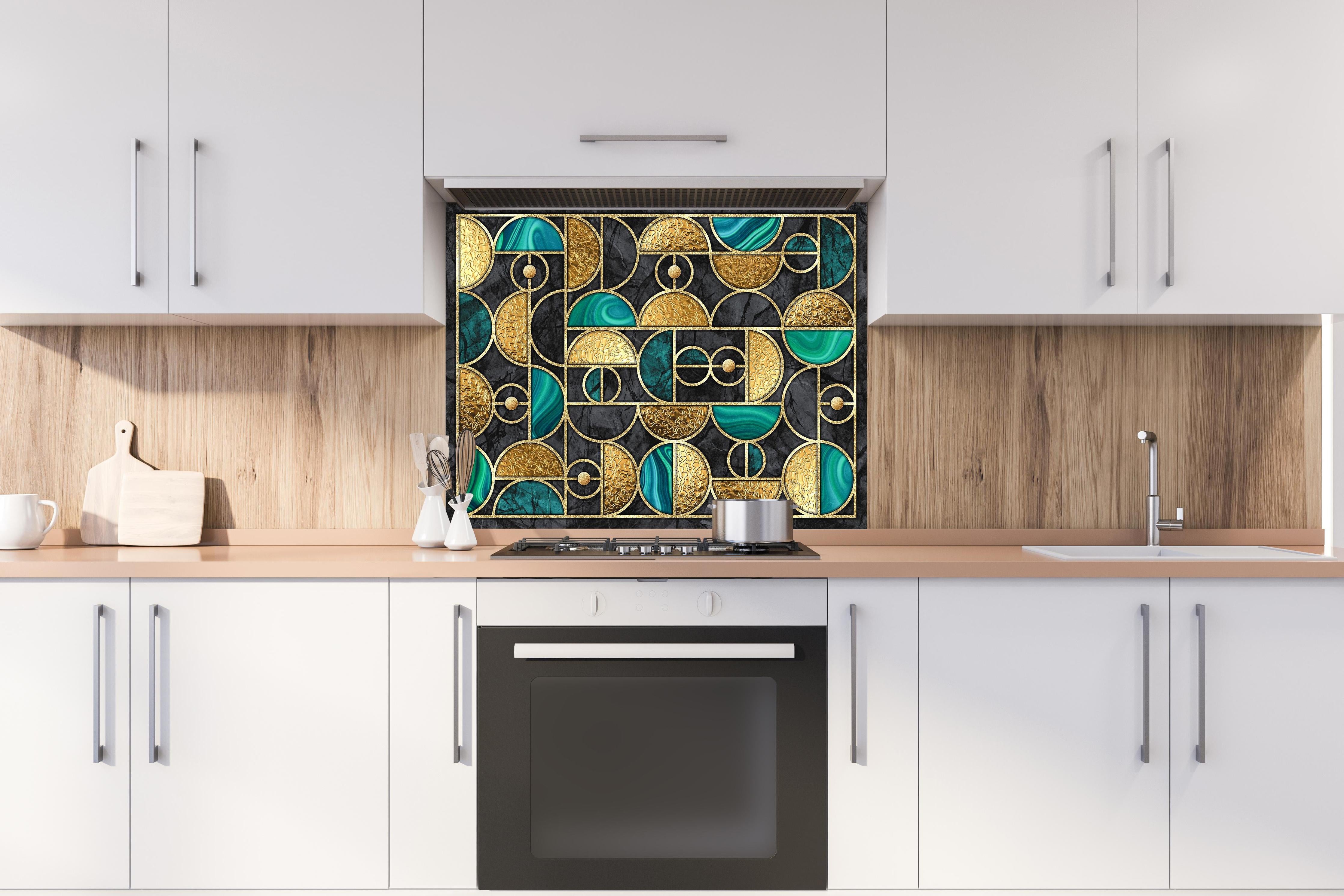 Spritzschutz - Geometrisches Schwarz-Gold-Grün Ringmosaik hinter einem Cerankochfeld zwischen Holz-Kochutensilien
