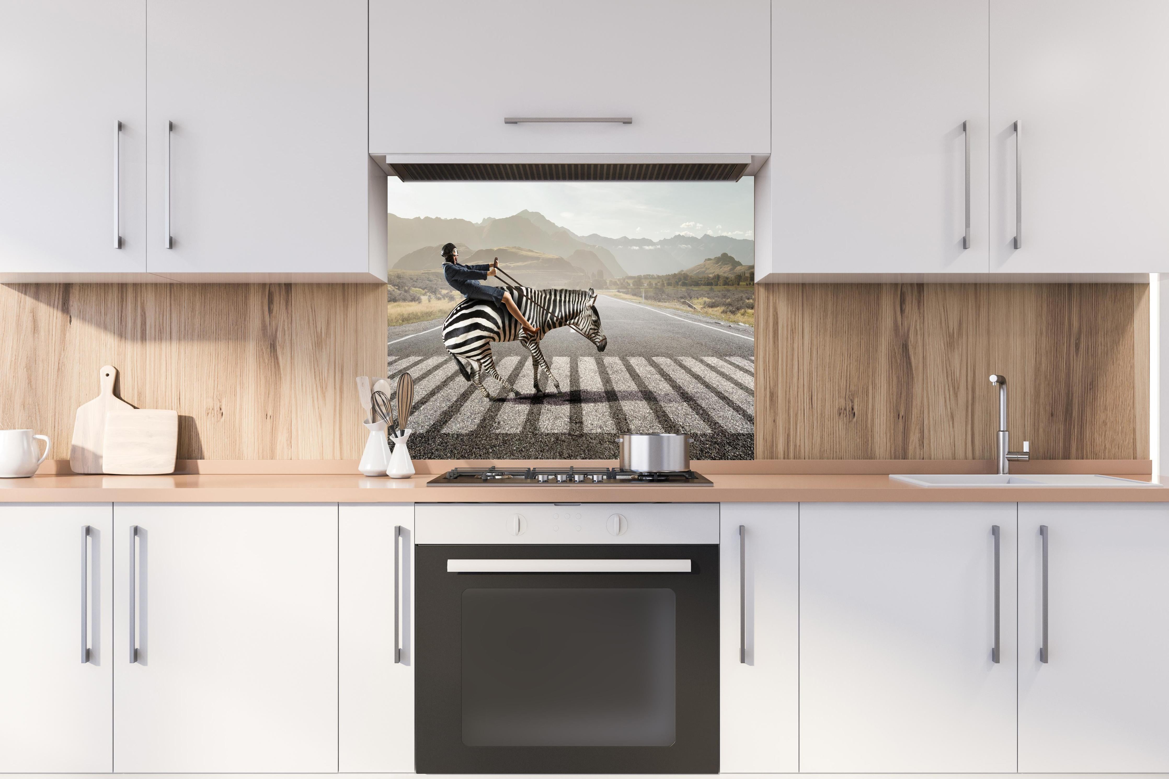 Spritzschutz - Geschäftsfrau reitet Zebra in Landschaft hinter einem Cerankochfeld zwischen Holz-Kochutensilien
