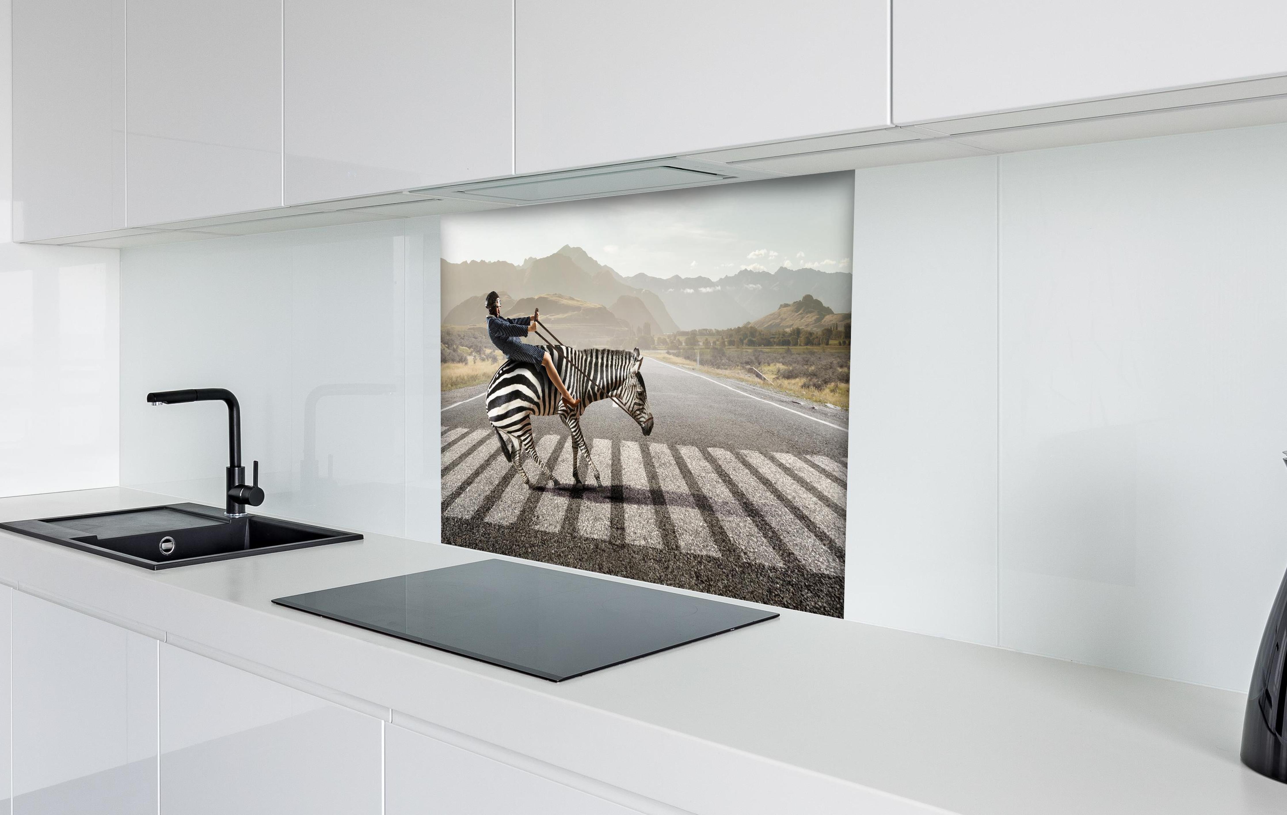 Spritzschutz - Geschäftsfrau reitet Zebra in Landschaft hinter einem Cerankochfeld zwischen Holz-Kochutensilien
