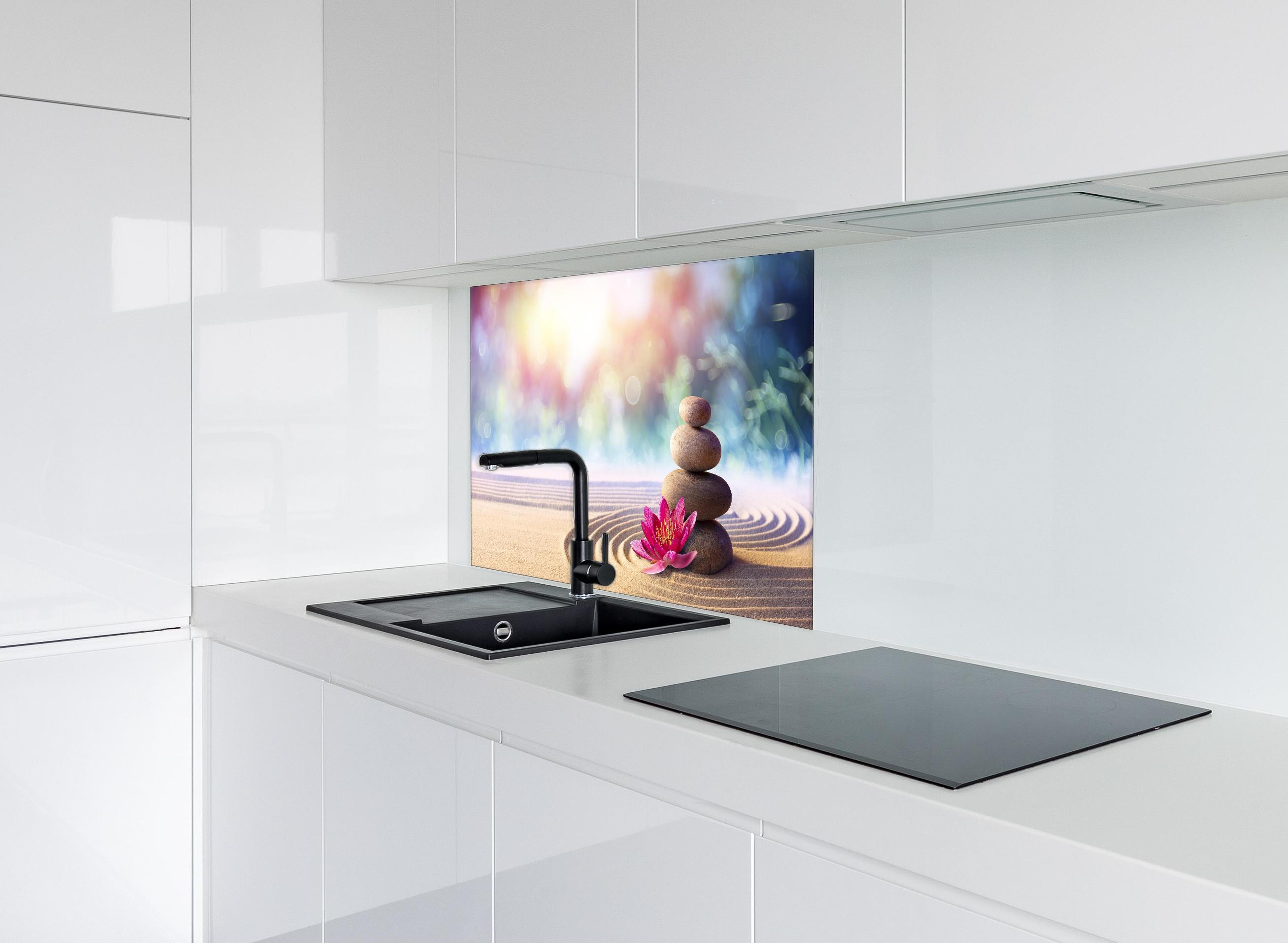 Spritzschutz - Gestapelte Meditation Steine hinter einem Cerankochfeld zwischen Holz-Kochutensilien
