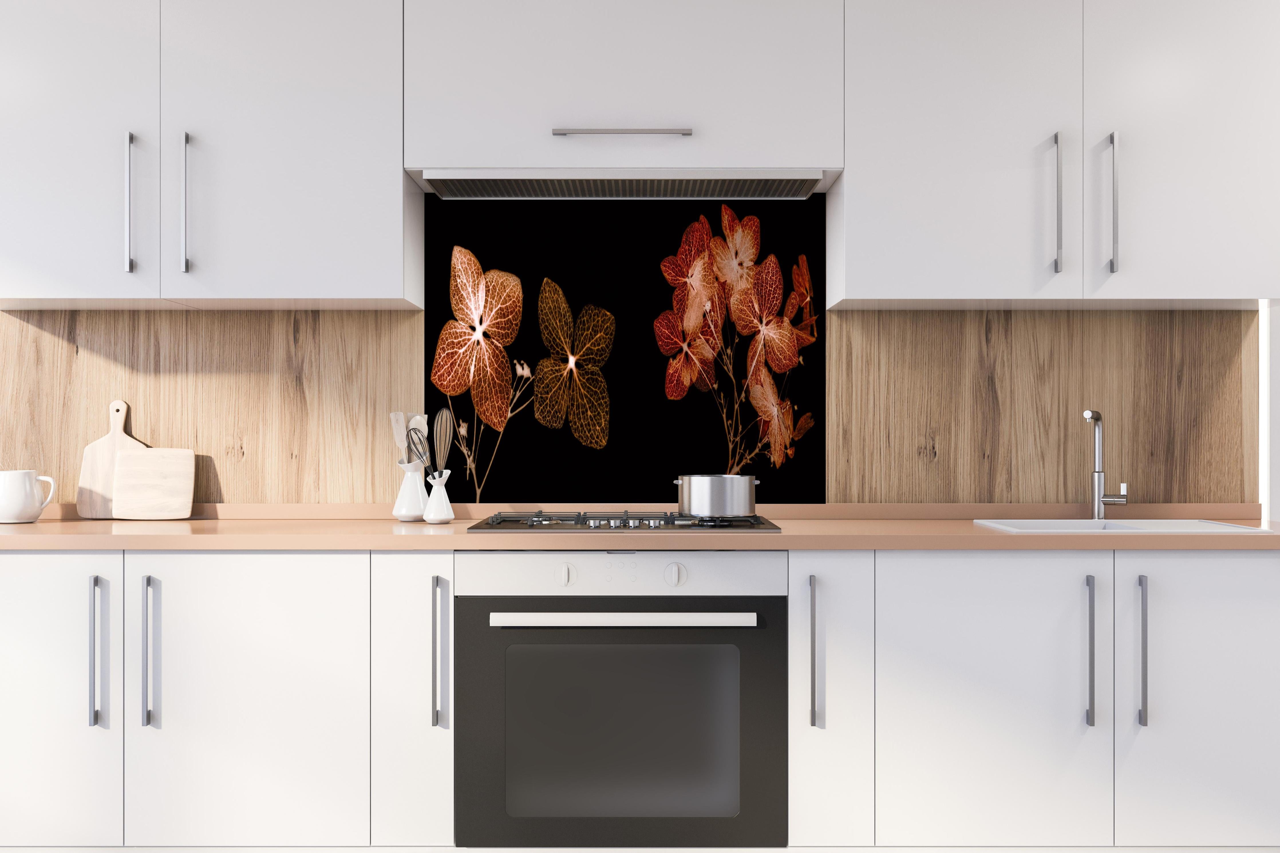 Spritzschutz - Getrocknete Hortensien Nahaufnahme auf Weiß hinter einem Cerankochfeld zwischen Holz-Kochutensilien
