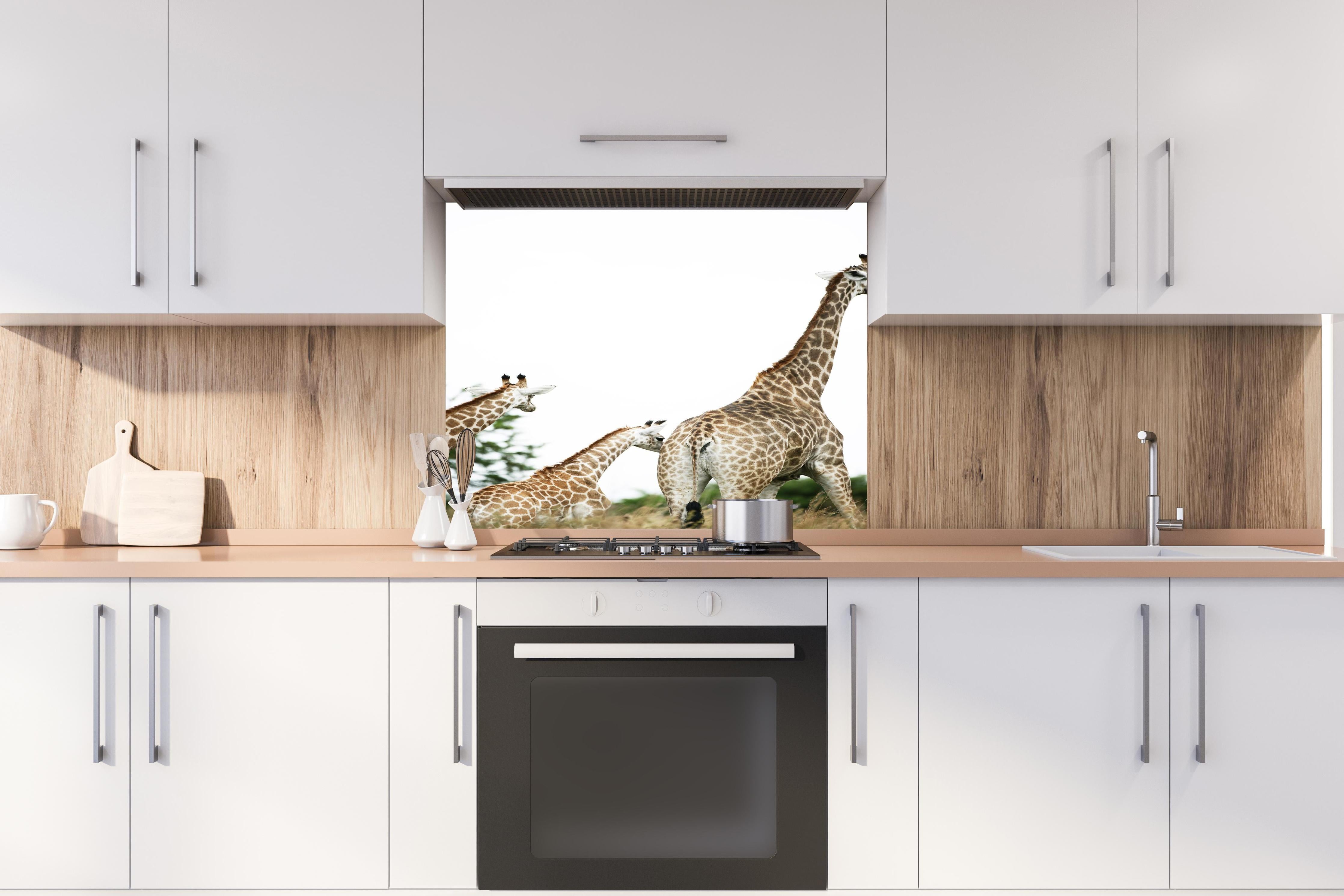 Spritzschutz - Giraffen Familie - hell hinter einem Cerankochfeld zwischen Holz-Kochutensilien
