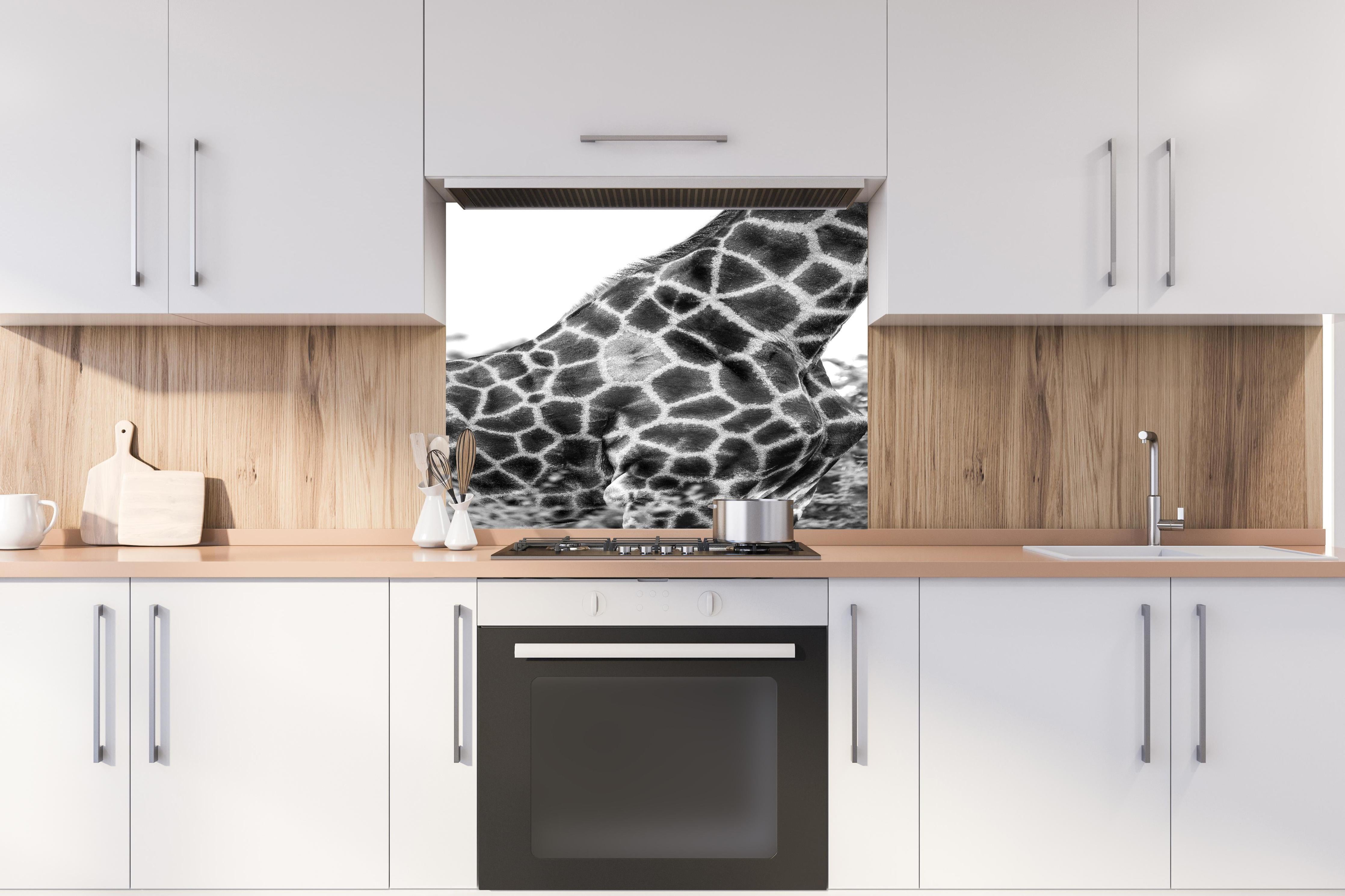 Spritzschutz - Giraffen Oberkörper hinter einem Cerankochfeld zwischen Holz-Kochutensilien
