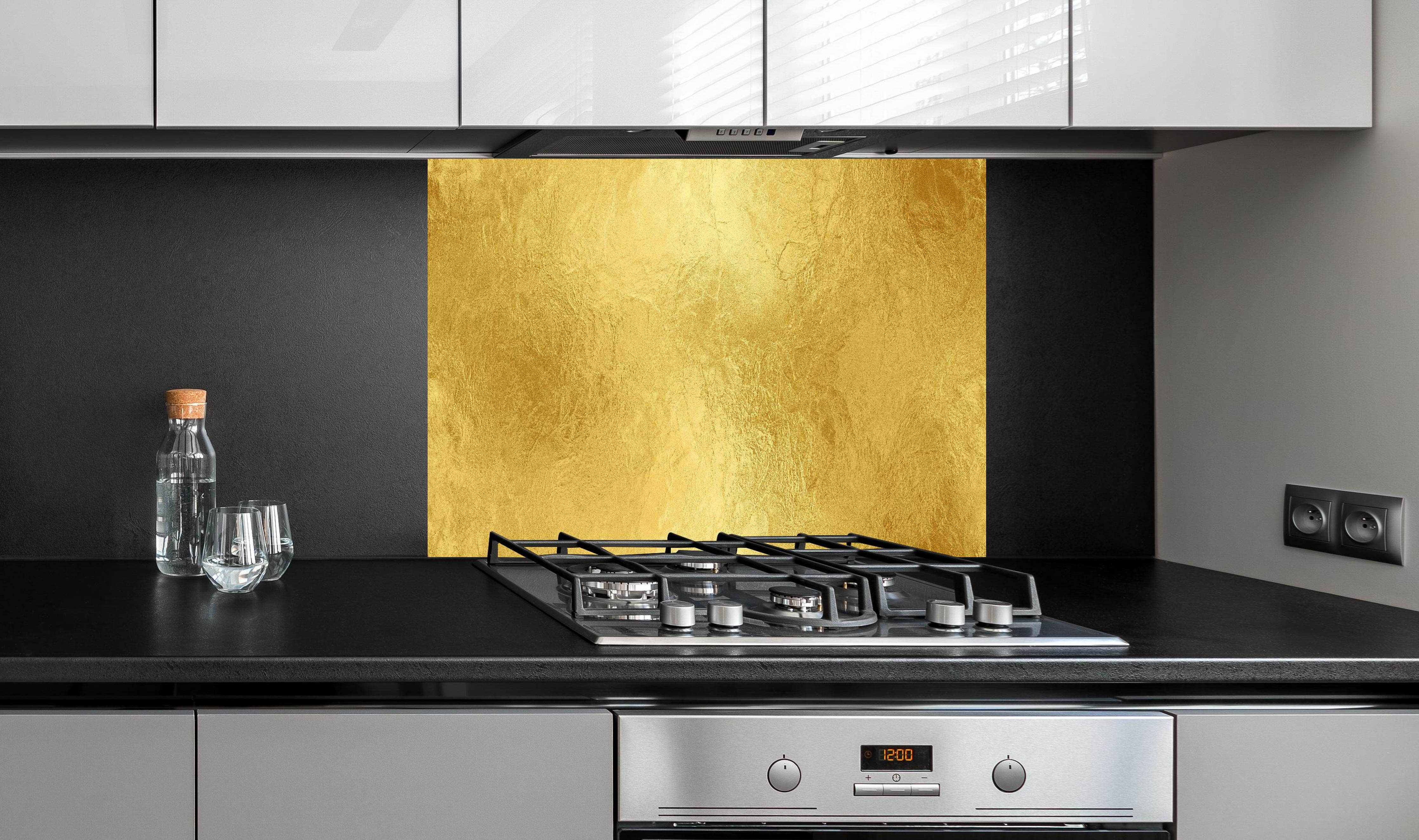 Spritzschutz - Glänzende Blattgold Textur hinter einem Cerankochfeld zwischen Holz-Kochutensilien
