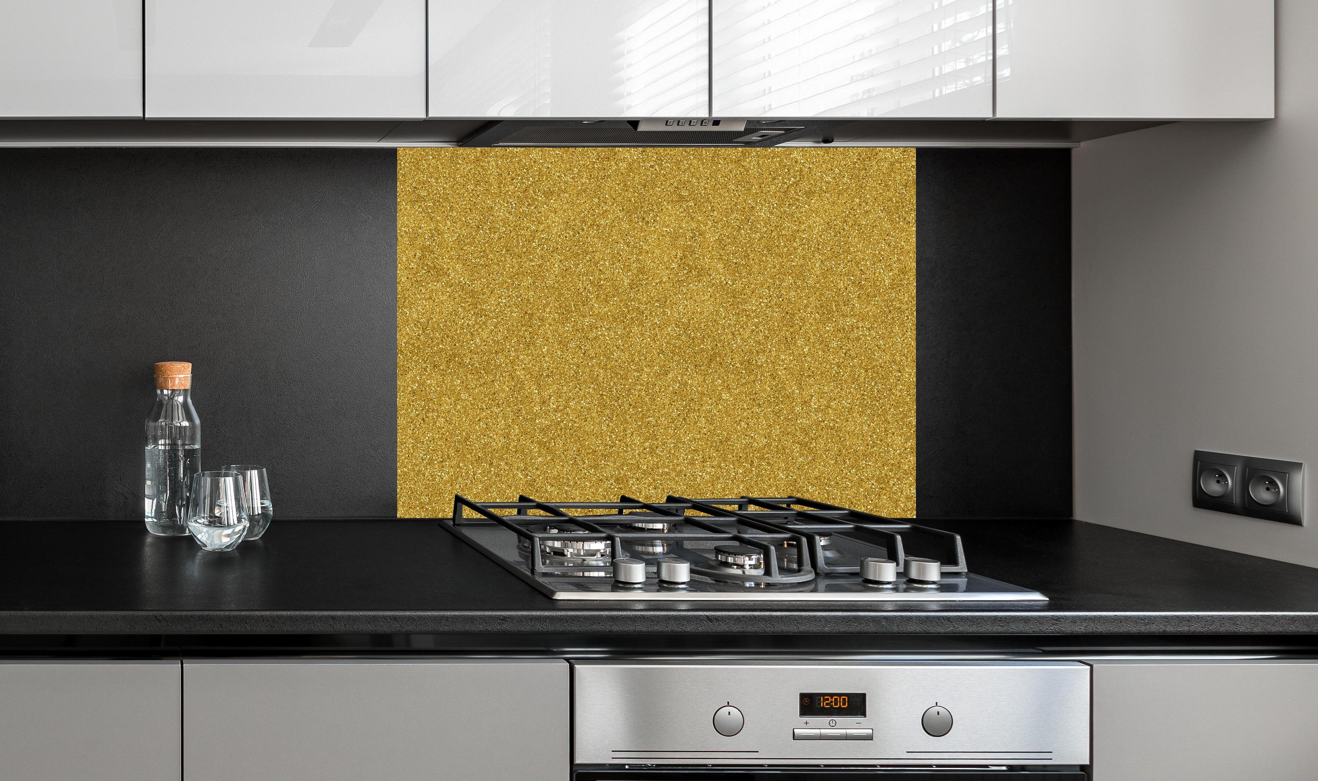 Spritzschutz - Gold Glitter Textur hinter einem Cerankochfeld zwischen Holz-Kochutensilien
